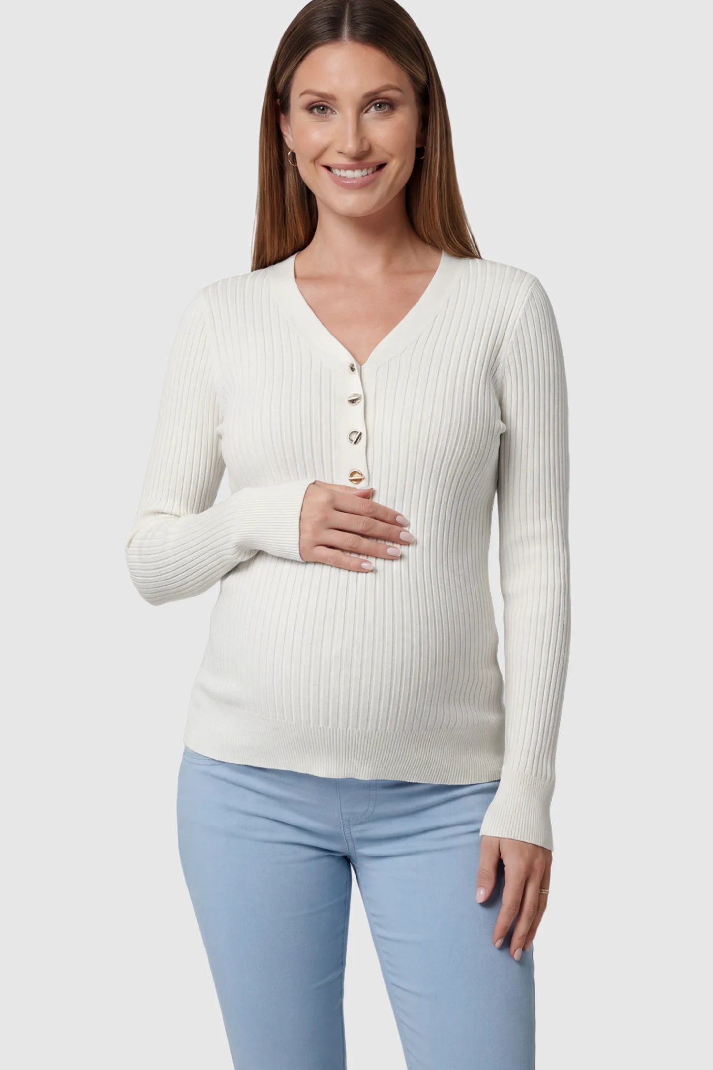 Ribbed Long Sleeve Maternity Henley Top Ribbed Maternity Henley Top in Off White featuring a functional button placket and vertical rib knit on a pregnant model showing front.