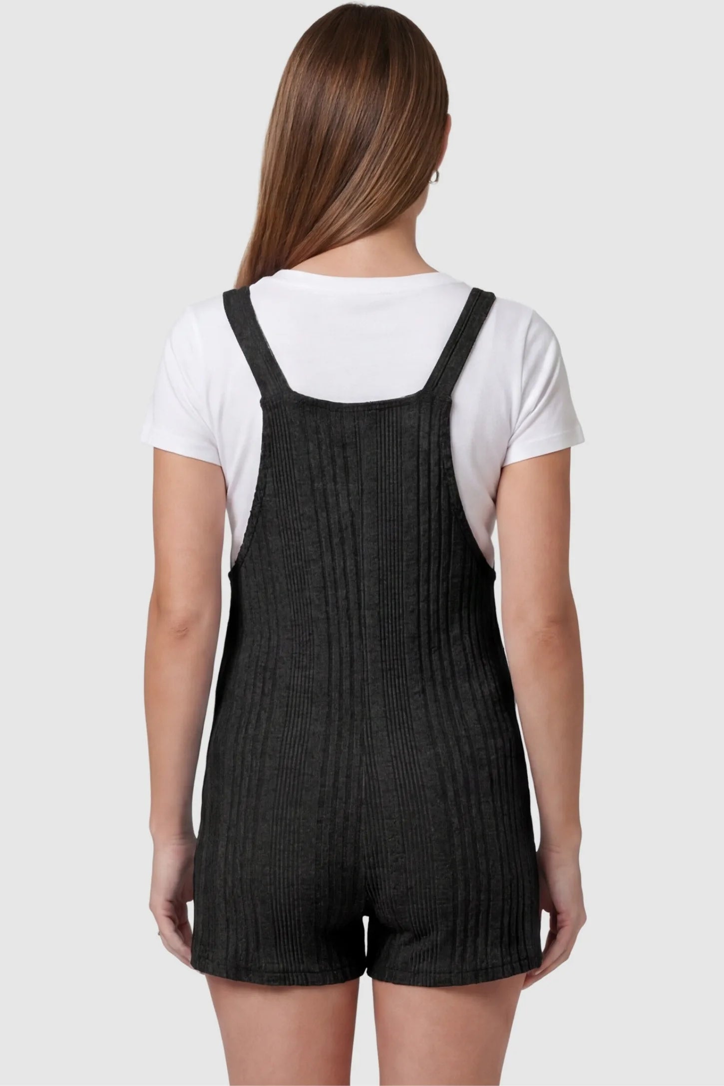 Ribbed Pocket Knit Maternity Romper Ribbed Pocket Knit Romper in Black featuring an all-over ribbed pattern on a pregnant model, back view.