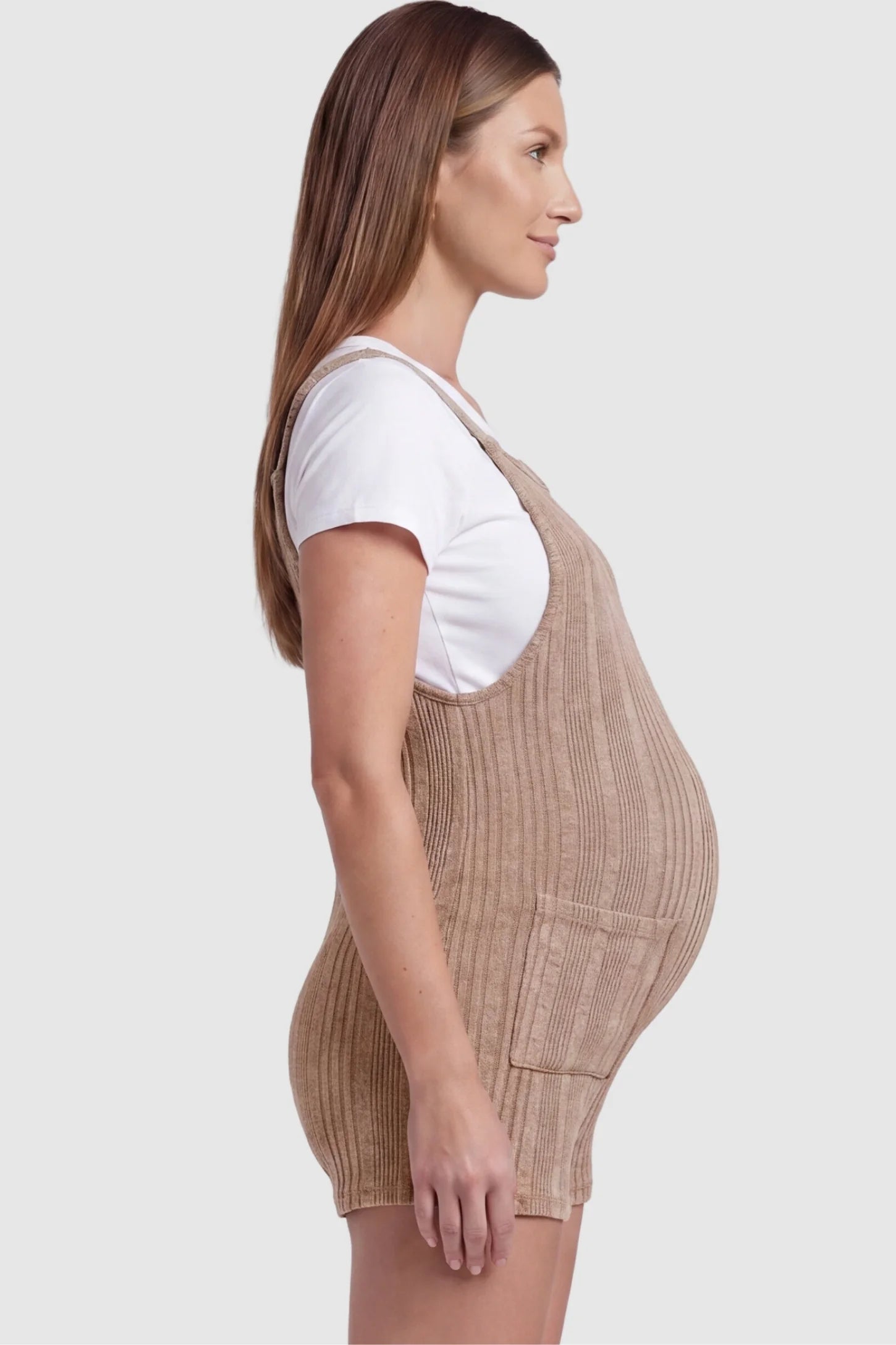 Ribbed Pocket Knit Maternity Romper Ribbed Pocket Knit Romper in Khaki featuring a flexible ribbed knit fabric on a pregnant model, side view.