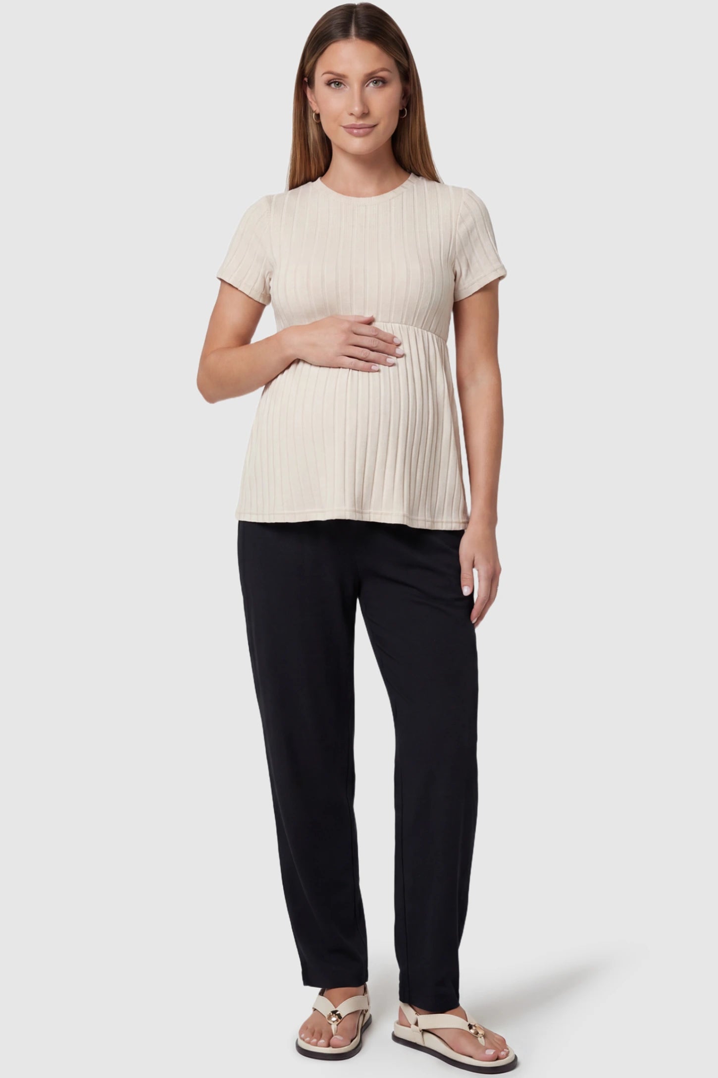 Ribbed Round Neck Short Sleeve Maternity Top Ribbed Round Neck Short Sleeve Maternity Top in Beige featuring a soft knit stretch and short sleeves on a pregnant model, full body view.