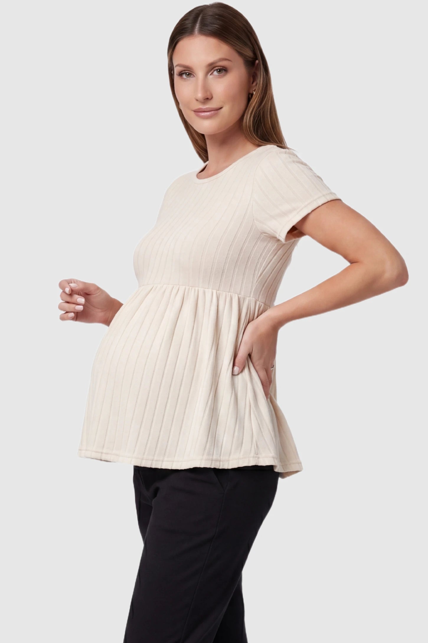 Ribbed Round Neck Short Sleeve Maternity Top Ribbed Round Neck Short Sleeve Maternity Top in Beige featuring a soft knit stretch and short sleeves on a pregnant model, side view.