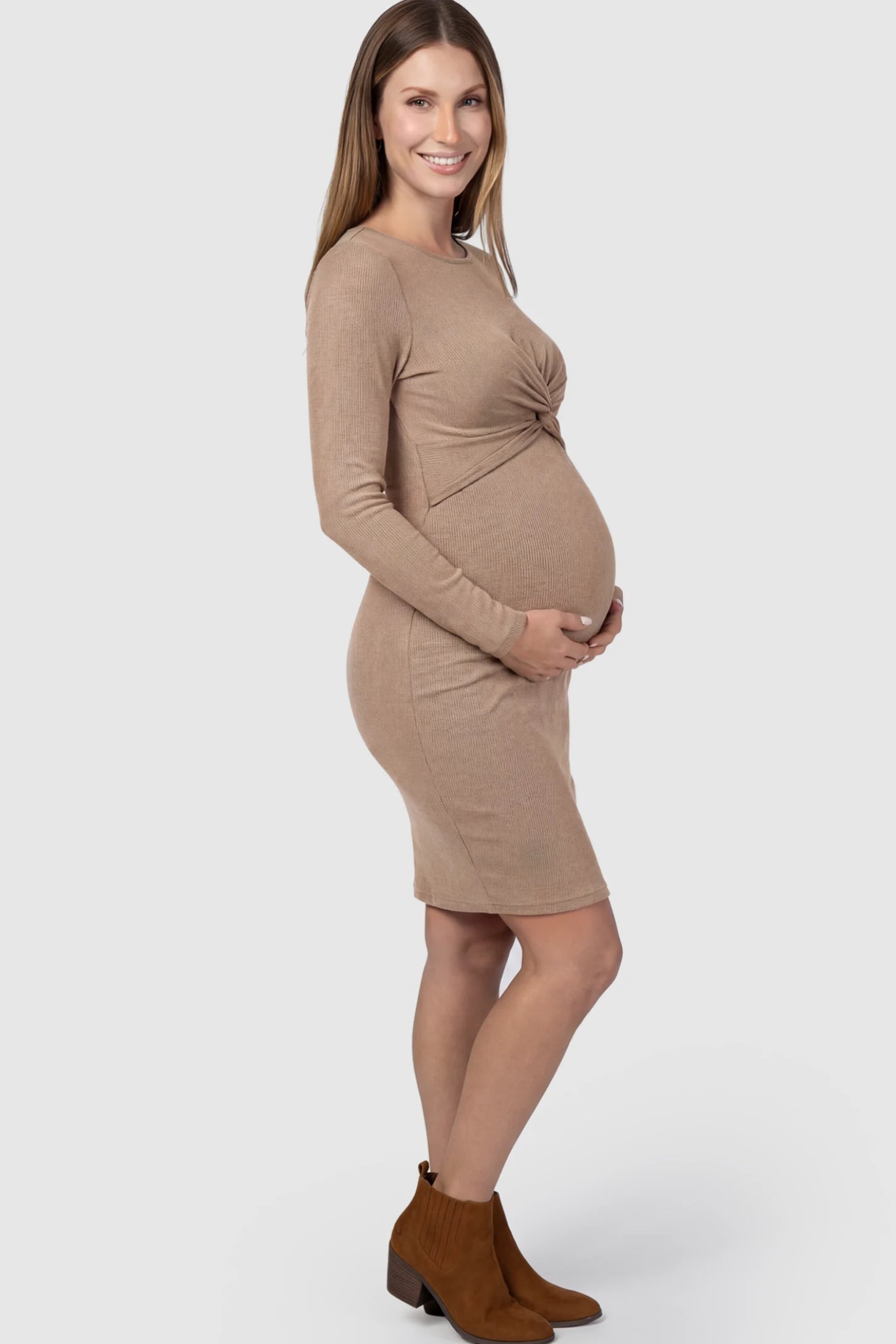 Ribbed Twist Front Long Sleeve Bodycon Maternity Short Dress Twist-Front Long Sleeve Ribbed Maternity Mini Dress in Beige featuring a textured knit finish on a pregnant model showing side.