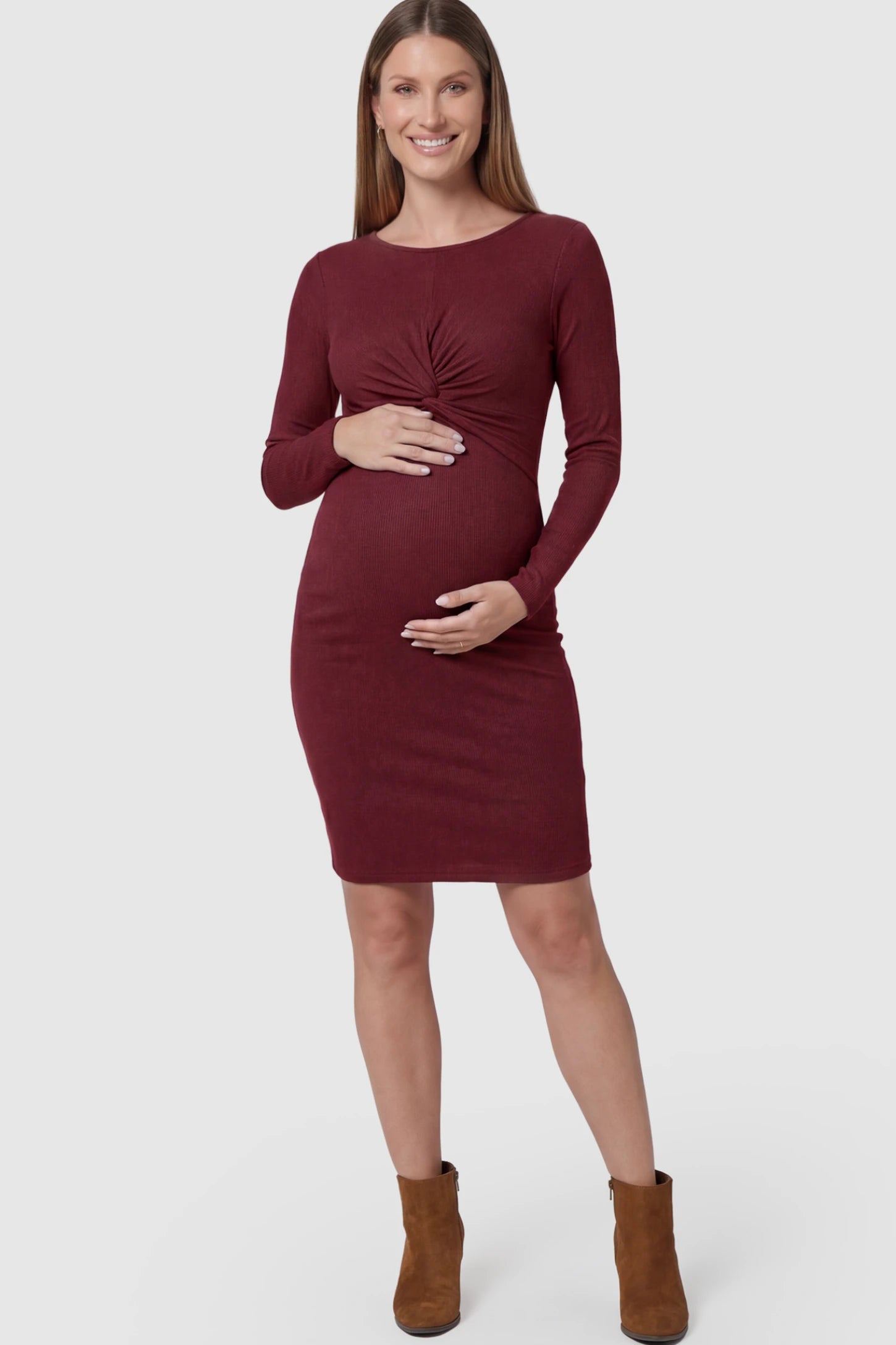 Ribbed Twist Front Long Sleeve Bodycon Maternity Short Dress Twist-Front Long Sleeve Ribbed Maternity Mini Dress in Red featuring a textured knit finish on a pregnant model showing front.