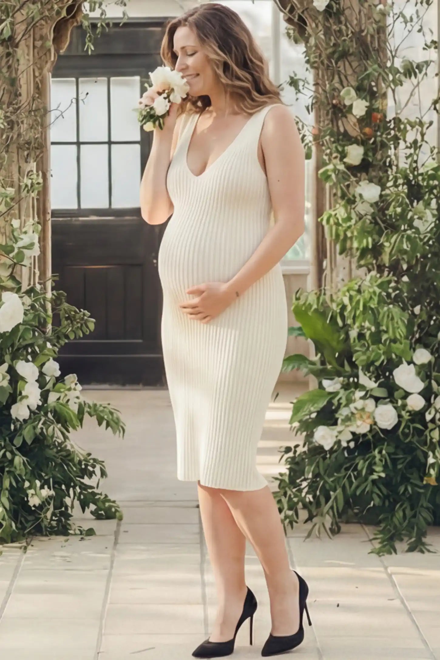 Ribbed V-Neck Bodycon Maternity Short Dress Ribbed V-Neck Bodycon Maternity Short Dress in Beige featuring a ribbed bodycon texture and sleeveless V-neck on a pregnant model in outdoor setting, side view.
