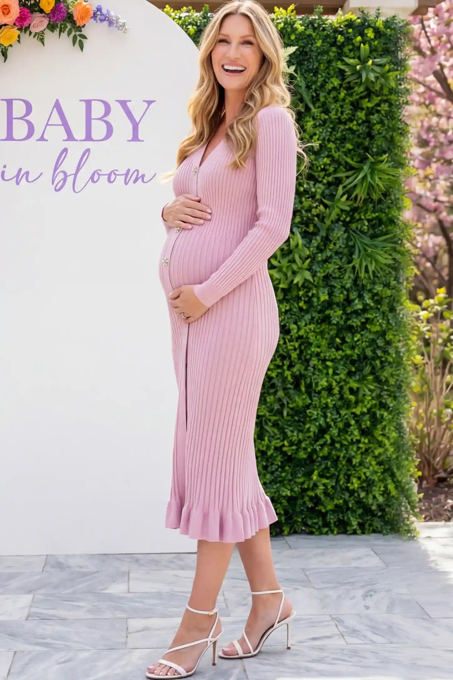 Ribbed V-Neck Maternity Midi Sweater Dress in Pink featuring rhinestone buttons on a pregnant woman showing side.