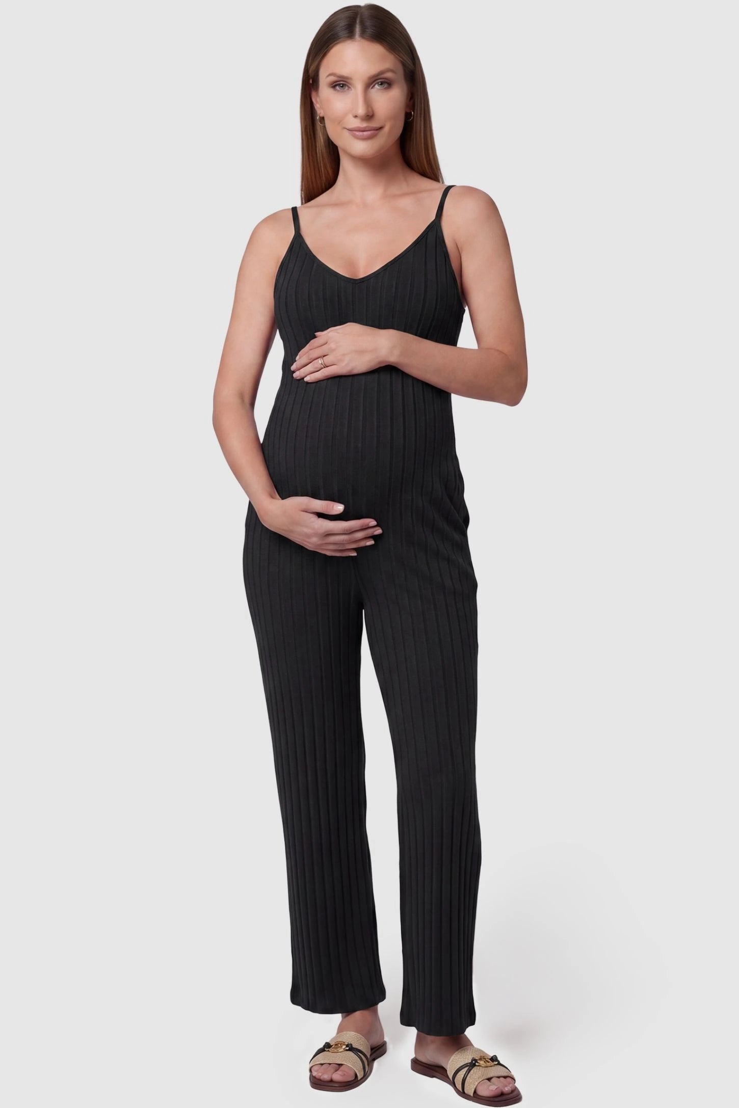 Ribbed Wide-Leg Maternity Camisole Jumpsuit Ribbed Wide-Leg Maternity Camisole Jumpsuit in Black featuring a vertical ribbed texture and relaxed wide leg on a pregnant model, front view.