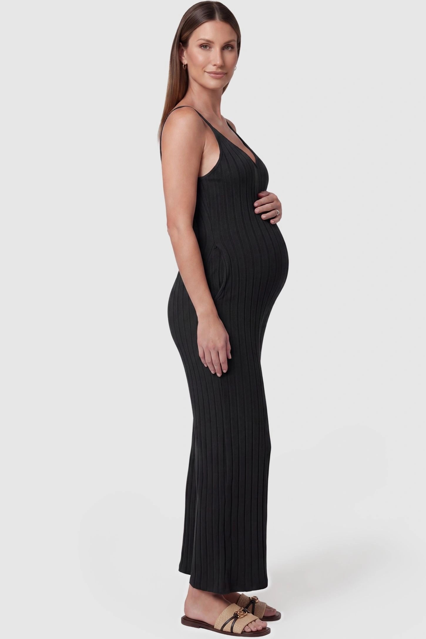 Ribbed Wide-Leg Maternity Camisole Jumpsuit Ribbed Wide-Leg Maternity Camisole Jumpsuit in Black featuring a flexible ribbed knit and wide-leg silhouette on a pregnant model, side view.