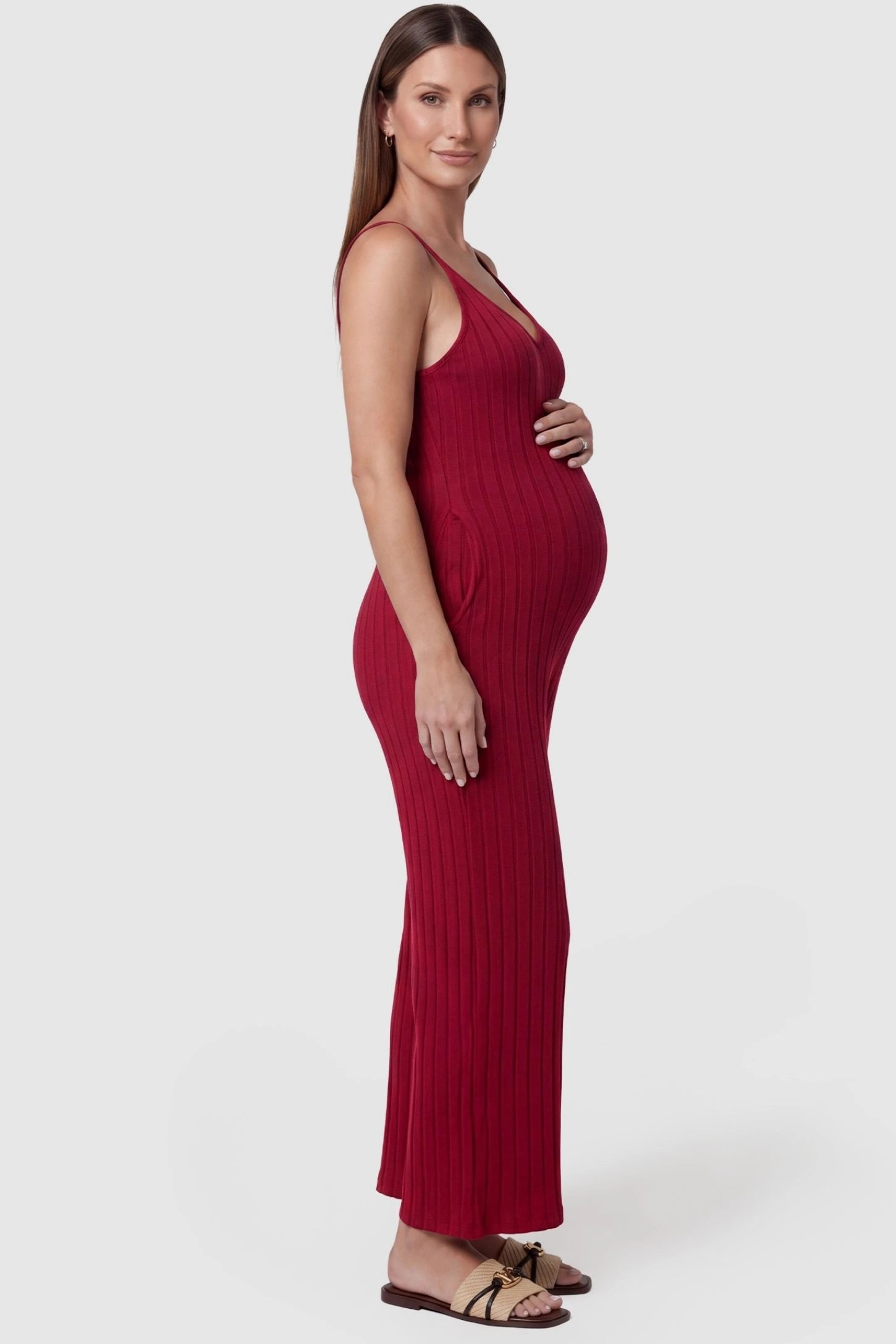 Ribbed Wide-Leg Maternity Camisole Jumpsuit Ribbed Wide-Leg Maternity Camisole Jumpsuit in Red featuring a flexible ribbed knit and wide-leg silhouette on a pregnant model, side view.