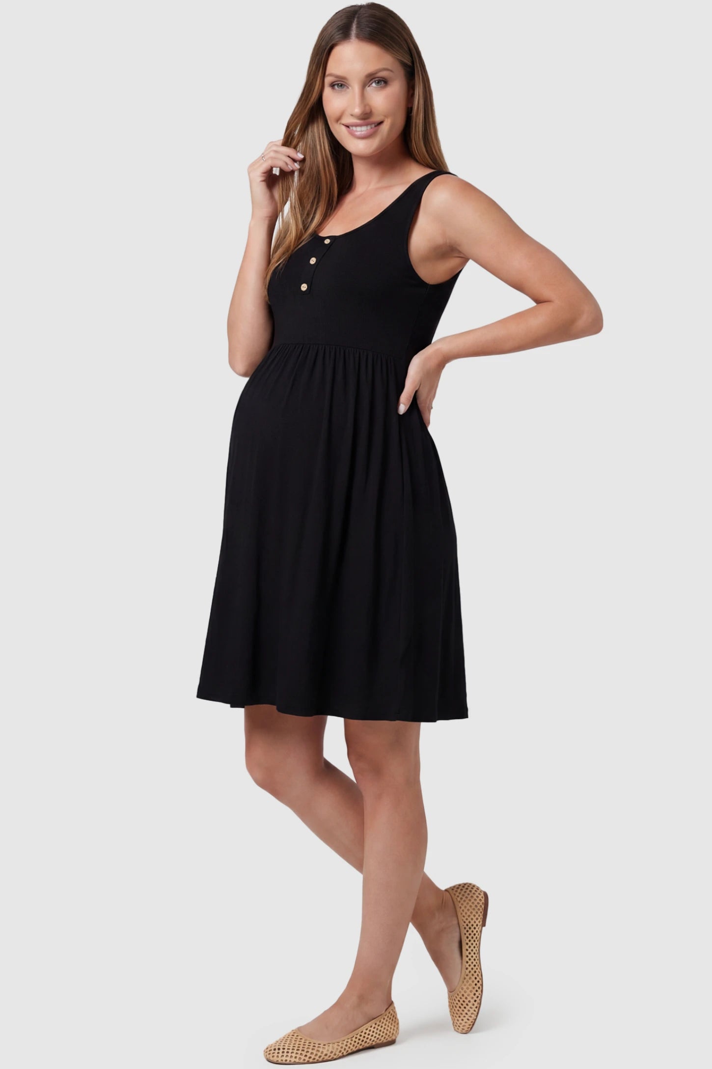 Round Neck Empire Waist Maternity Short Dress Round Neck Empire Waist Maternity Short Dress in Black featuring soft knit stretch on a pregnant model, side view.