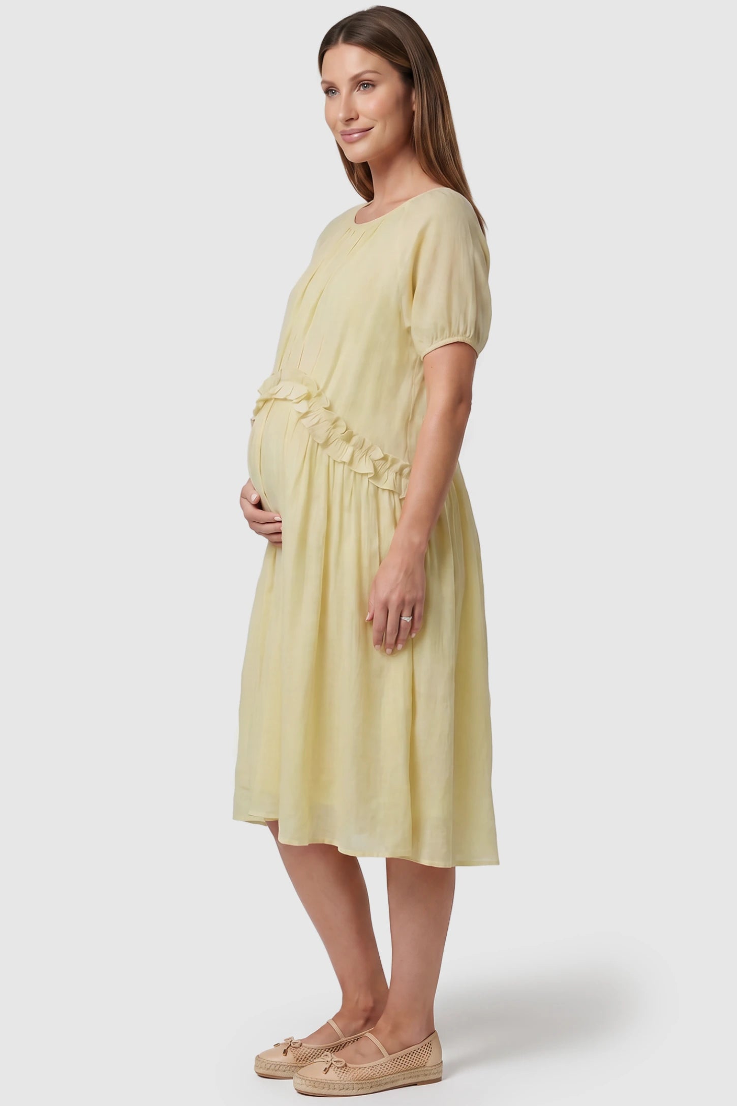 Round Neck Short Sleeve Flowy Maternity Midi Dress Round Neck Short Sleeve Flowy Maternity Midi Dress in Yellow featuring ruffled waist on a pregnant model, side view.