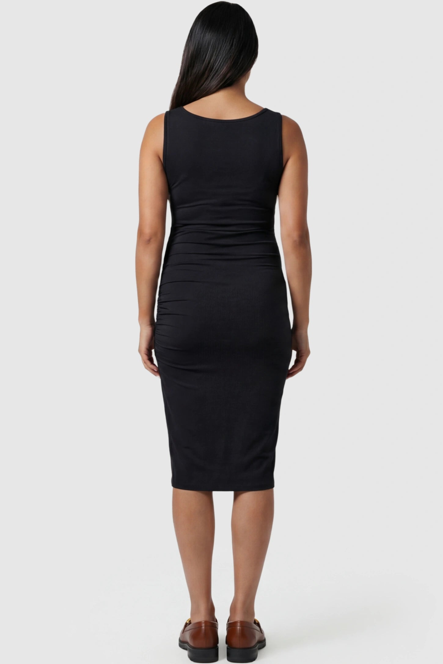 Ruched Tulip-Hem Sleeveless Bodycon Maternity Dress Ruched Tulip-Hem Bodycon Maternity Dress in Black featuring a side-ruched pencil skirt on a pregnant model showing back.
