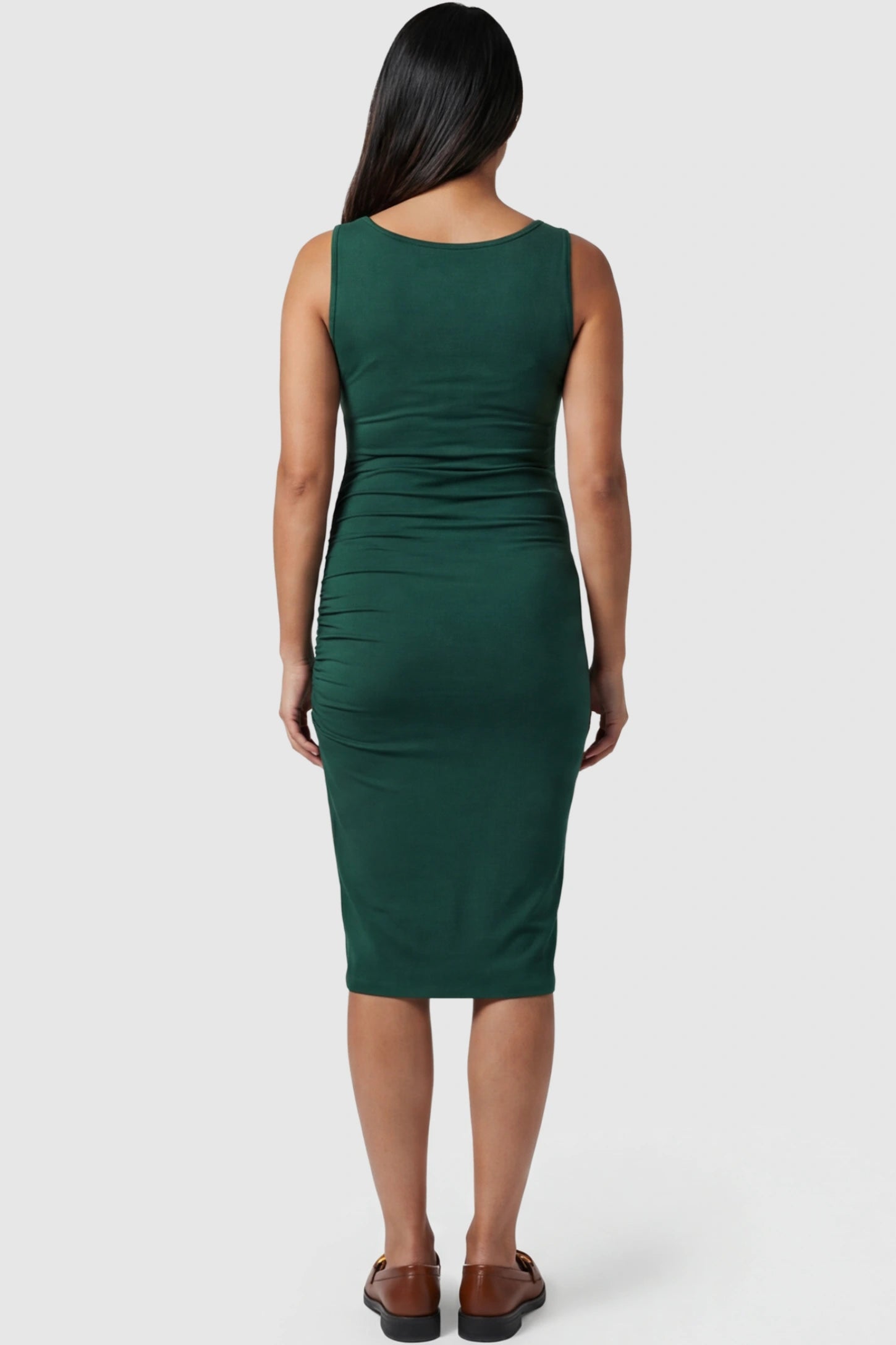 Ruched Tulip-Hem Sleeveless Bodycon Maternity Dress Ruched Tulip-Hem Bodycon Maternity Dress in Dark Green featuring a side-ruched pencil skirt on a pregnant model showing back.