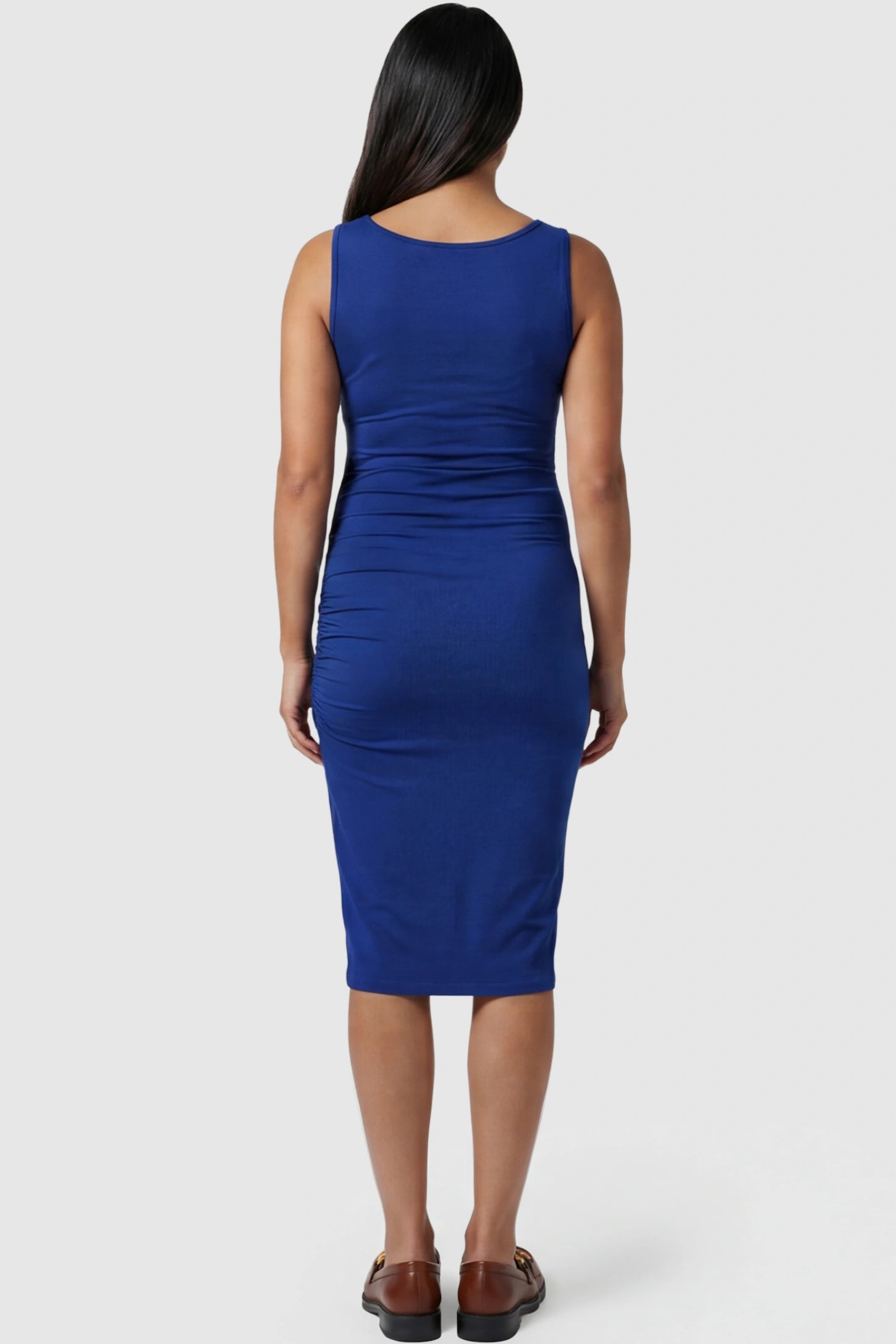 Ruched Tulip-Hem Sleeveless Bodycon Maternity Dress Ruched Tulip-Hem Bodycon Maternity Dress in Navy Blue featuring a side-ruched pencil skirt on a pregnant model showing back.