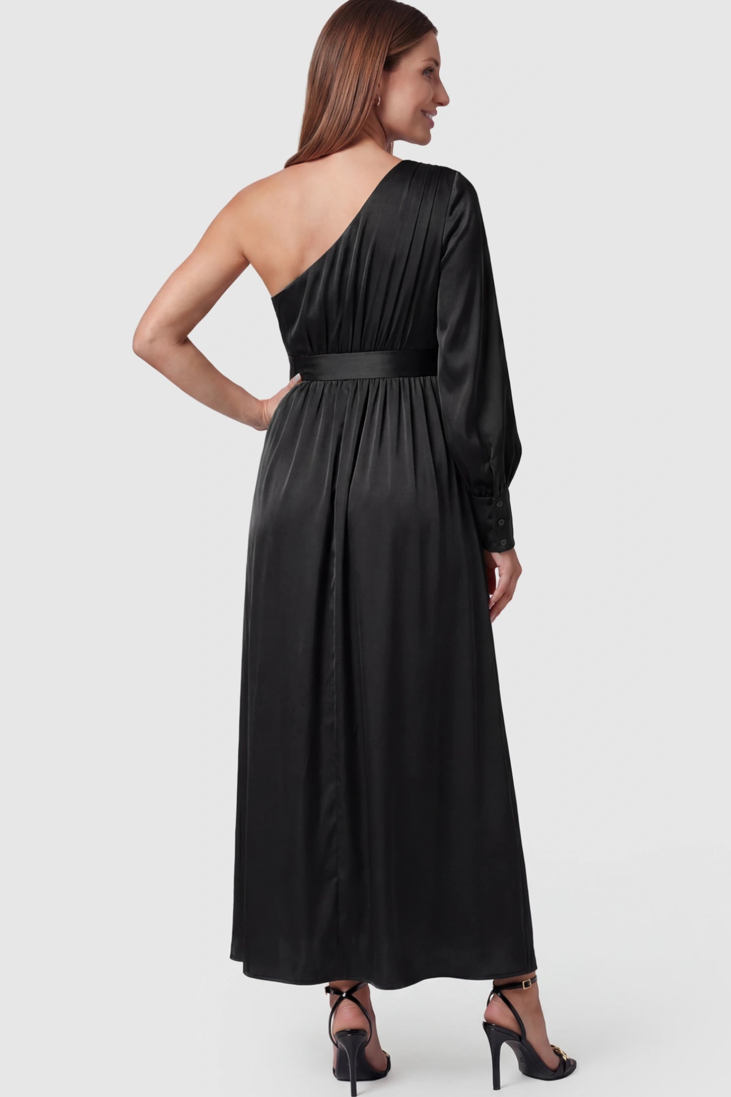 Satin One Shoulder Belted Maternity Maxi Dress Satin One-Shoulder Belted Maternity Maxi Dress in Black featuring a side slit and waist tie on a pregnant model showing back.
