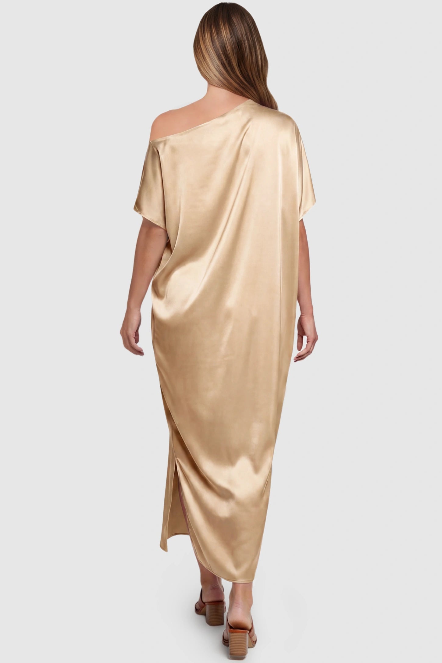 Satin One Shoulder Side Slit Maternity Maxi Dress Satin One Shoulder Side Slit Maternity Maxi Dress in Apricot featuring a draped batwing sleeve on a pregnant model, back view.