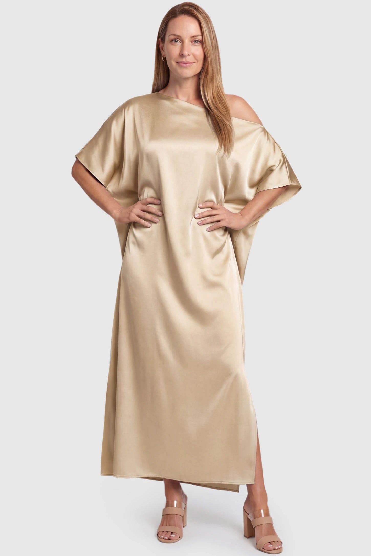 Satin One Shoulder Side Slit Maternity Maxi Dress Satin One Shoulder Side Slit Maternity Maxi Dress in Apricot featuring a draped batwing sleeve on a postpartum model, front view.