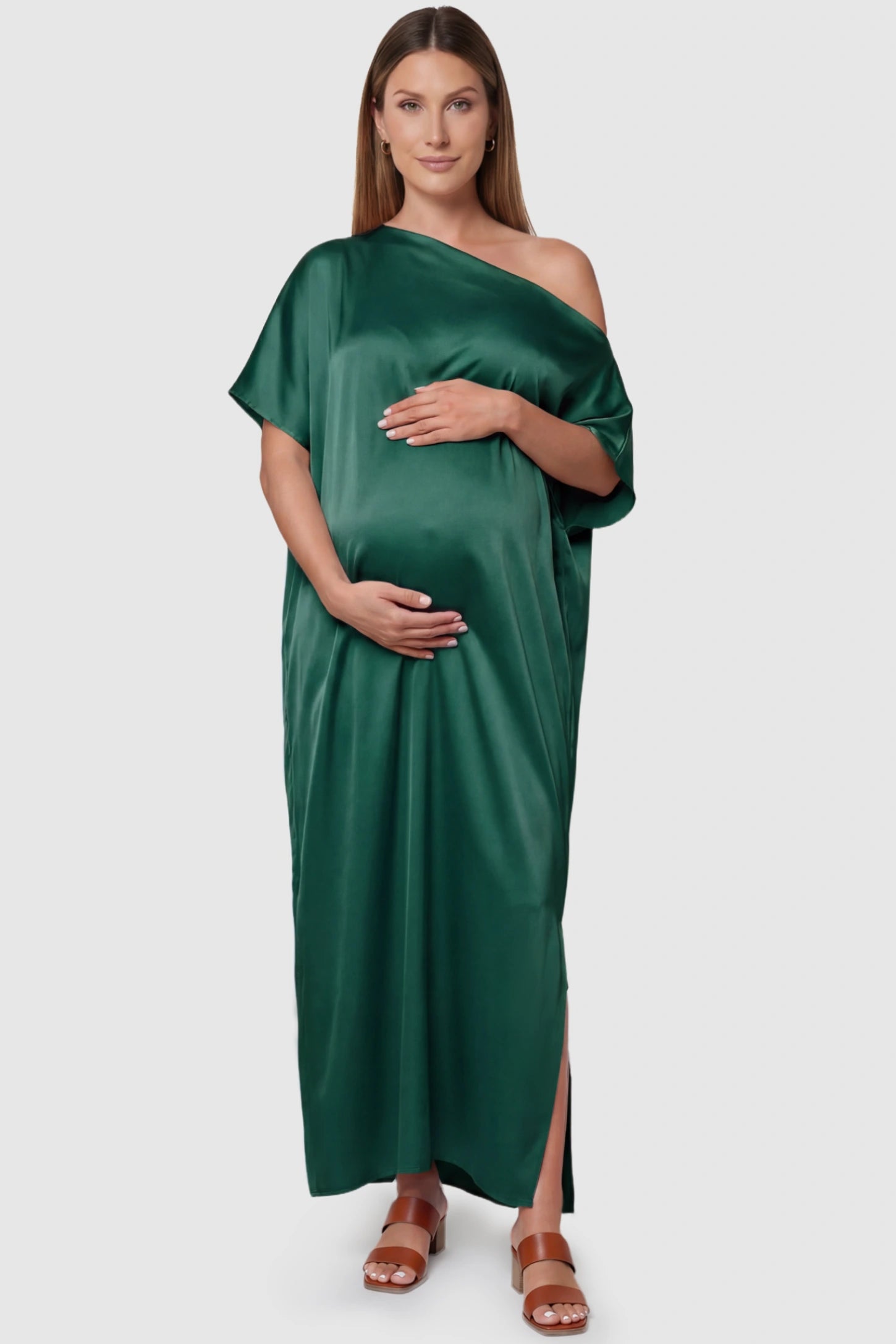 Satin One Shoulder Side Slit Maternity Maxi Dress Satin One Shoulder Side Slit Maternity Maxi Dress in Dark Green featuring a draped batwing sleeve on a pregnant model, front view.