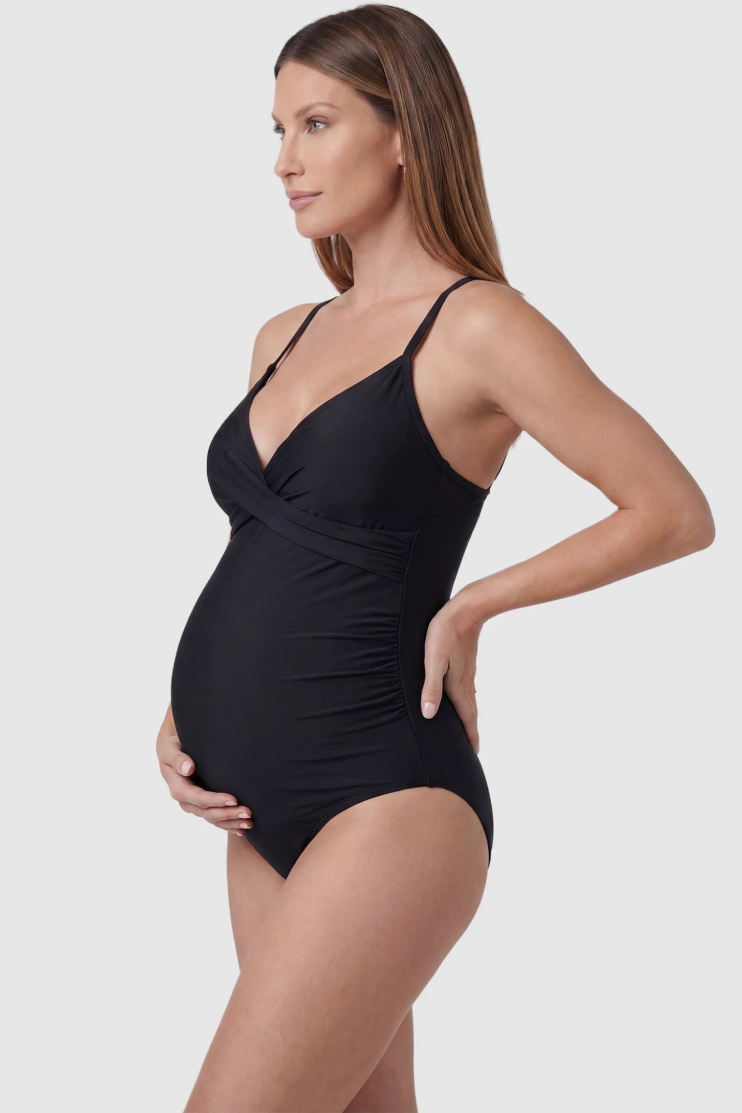 Side Ruched Crossover V-Neck Maternity Swimsuit Side Ruched Crossover V-Neck Maternity Swimsuit in Black featuring spaghetti straps and a crossover neckline on a pregnant model, side view.