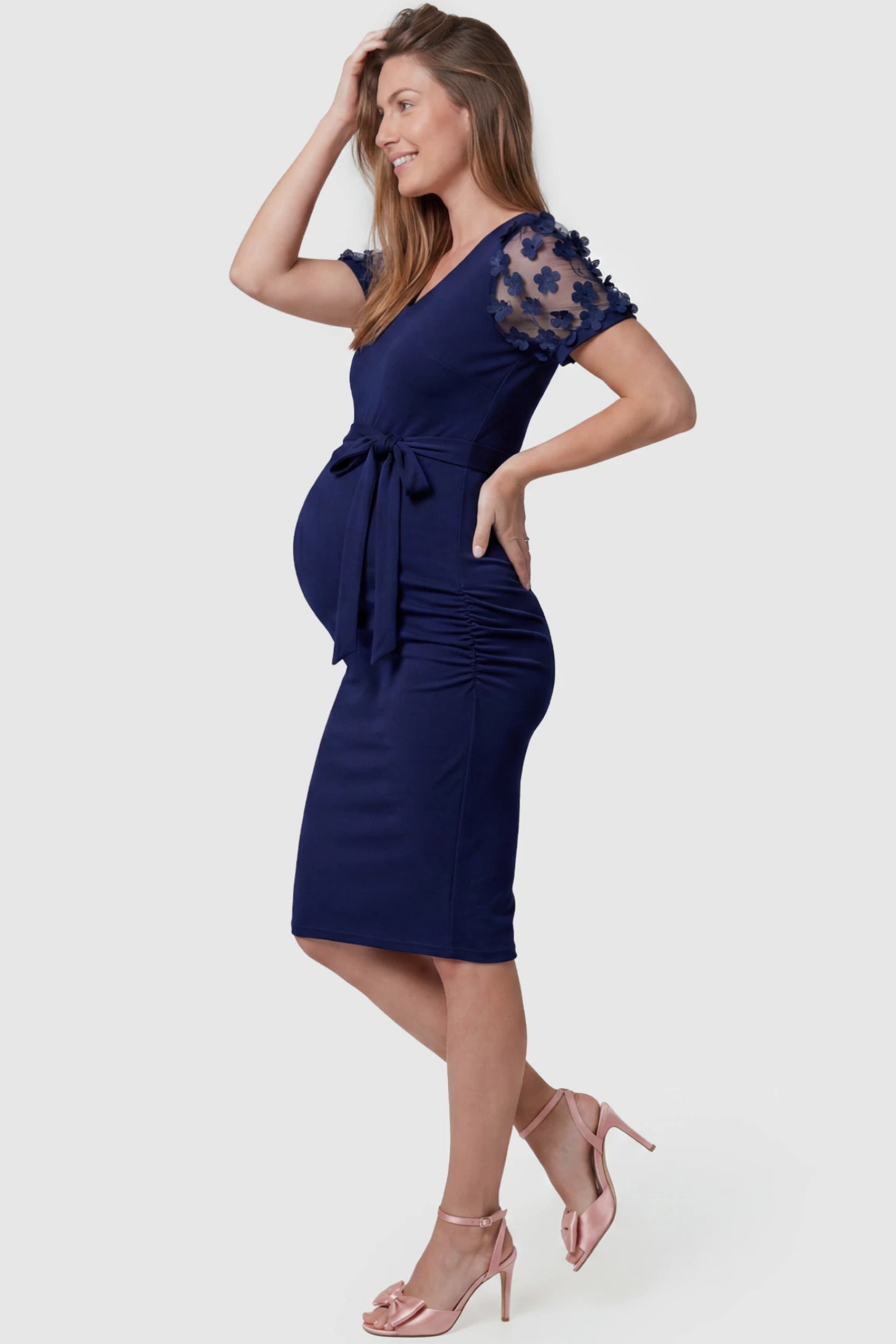 Side Ruched Round Neck Short Sleeve Maternity Short Dress Side Ruched Round Neck Short Sleeve Maternity Short Dress in dark blue featuring floral-detailed sleeves on a pregnant model, side view.