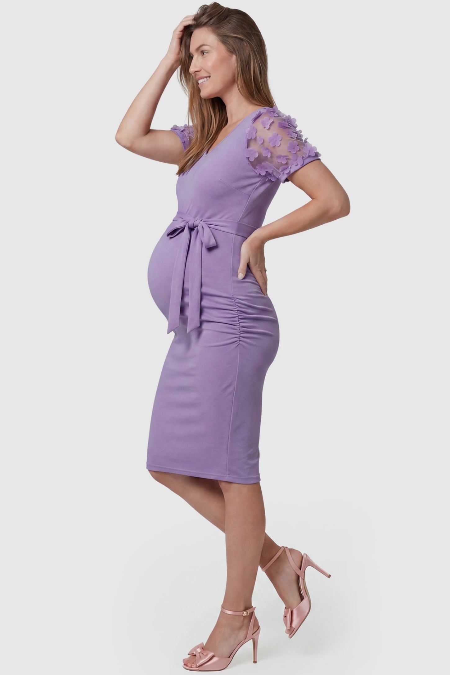 Side Ruched Round Neck Short Sleeve Maternity Short Dress Side Ruched Round Neck Short Sleeve Maternity Short Dress in purple featuring floral-detailed sleeves on a pregnant model, side view.