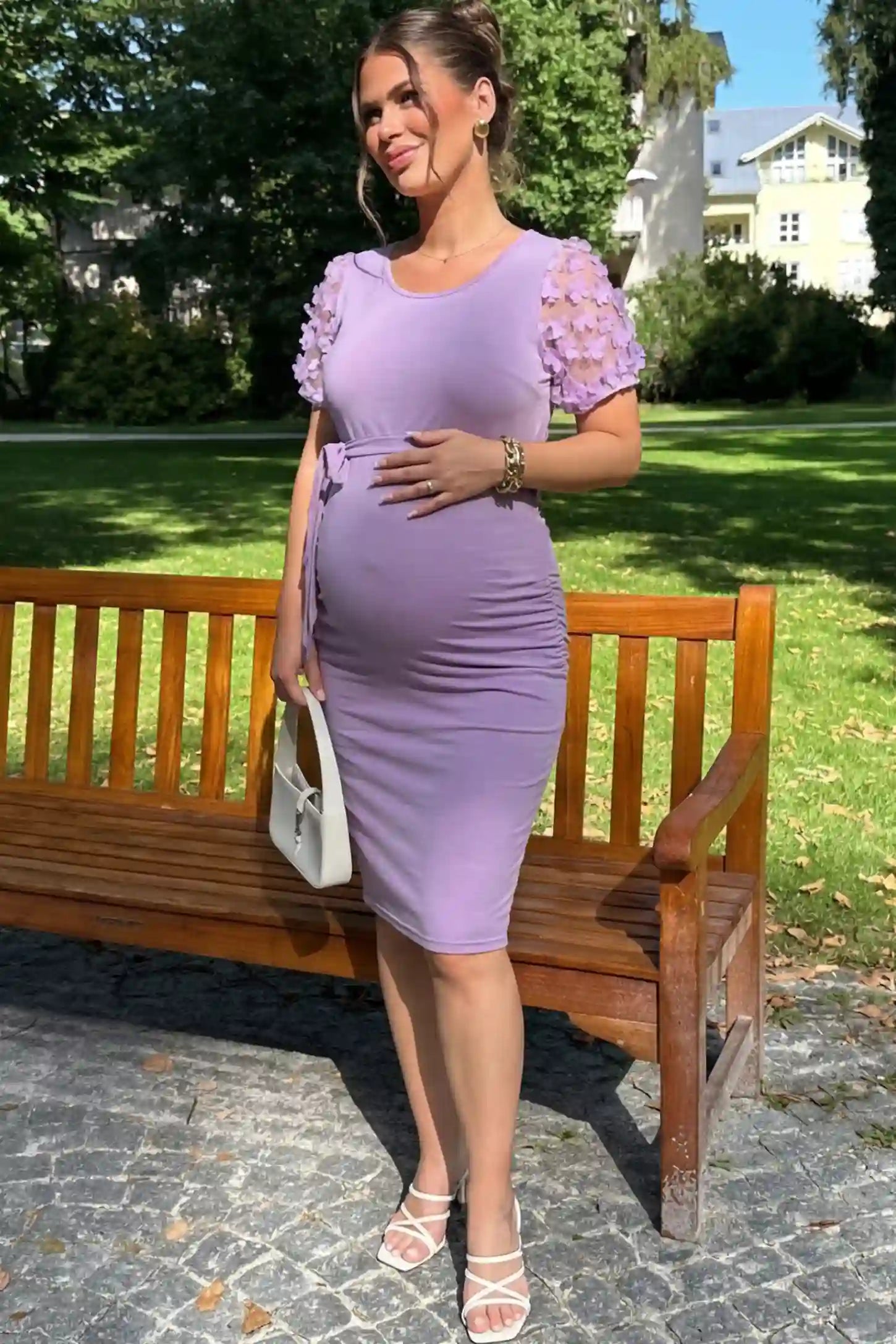 Side Ruched Round Neck Short Sleeve Maternity Short Dress Side Ruched Round Neck Short Sleeve Maternity Short Dress in purple featuring floral-detailed sleeves on a pregnant woman in outdoor setting, front view.