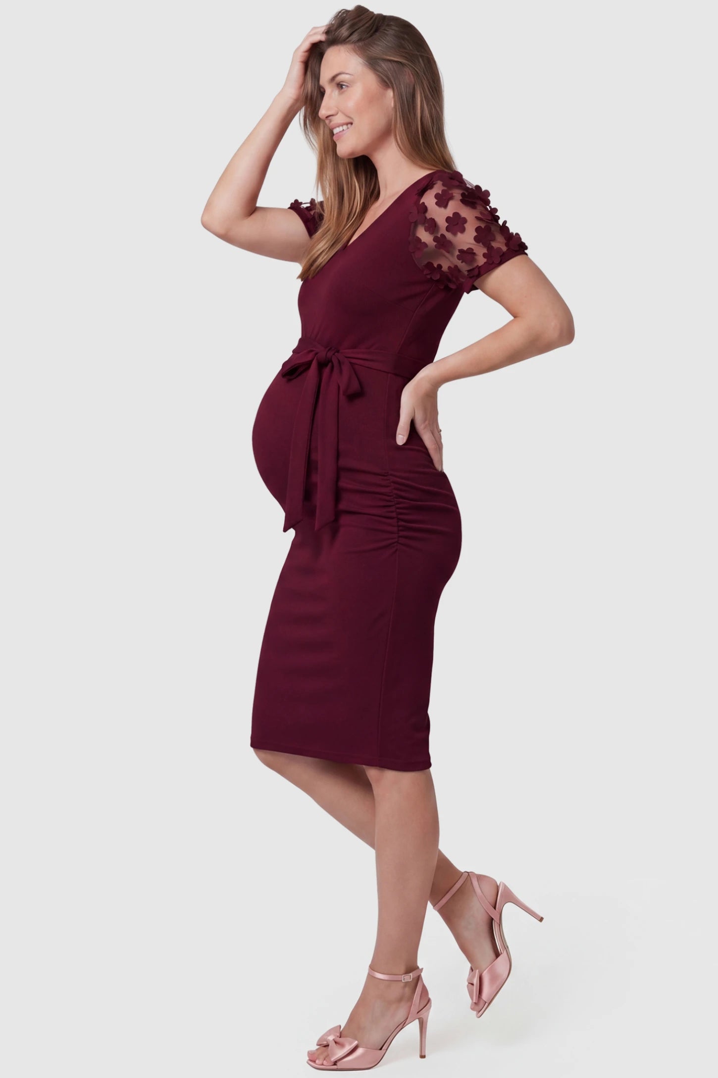 Side Ruched Round Neck Short Sleeve Maternity Short Dress Side Ruched Round Neck Short Sleeve Maternity Short Dress in wine red featuring floral-detailed sleeves on a pregnant model, side view.