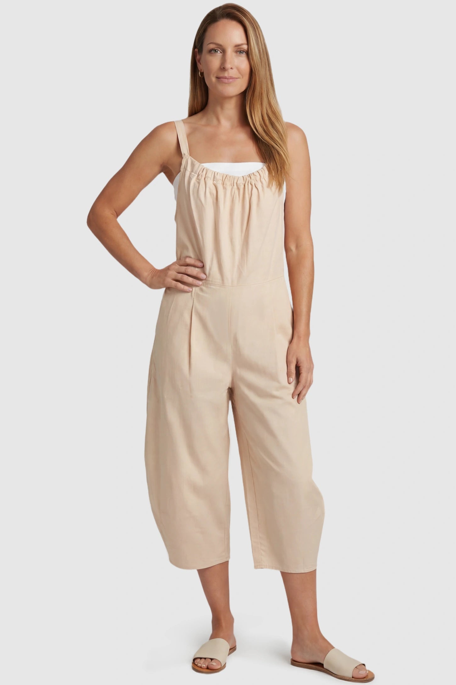 Sleeveless Balloon-Leg Maternity Jumpsuit Sleeveless Balloon-Leg Maternity Jumpsuit in Beige featuring deep side pockets on a postpartum model, front view.