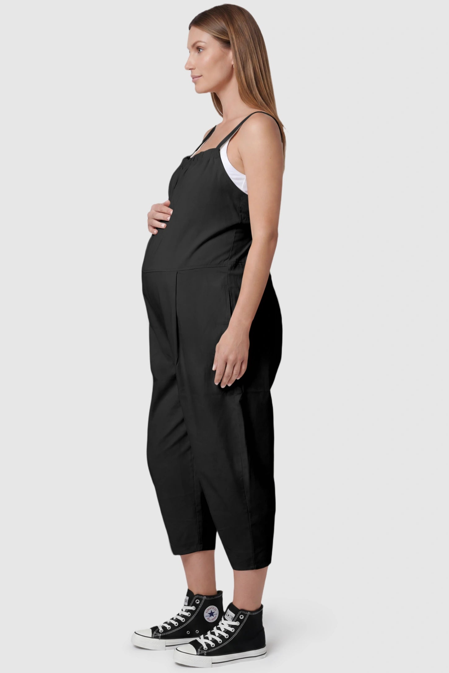 Sleeveless Balloon-Leg Maternity Jumpsuit Sleeveless Balloon-Leg Maternity Jumpsuit in Black featuring deep side pockets on a pregnant model, side view.