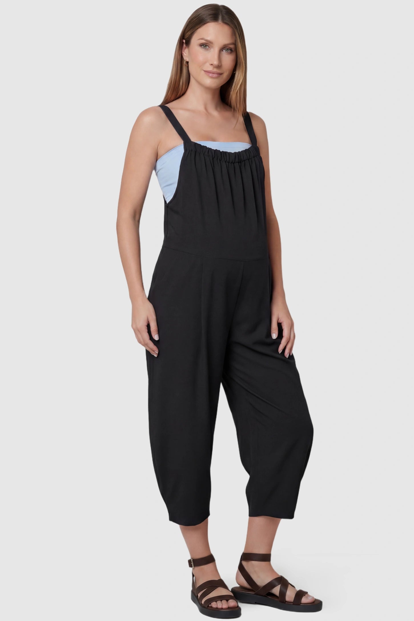 Sleeveless Balloon-Leg Maternity Jumpsuit Sleeveless Balloon-Leg Maternity Jumpsuit in Black featuring deep side pockets on a pregnant model, front view.