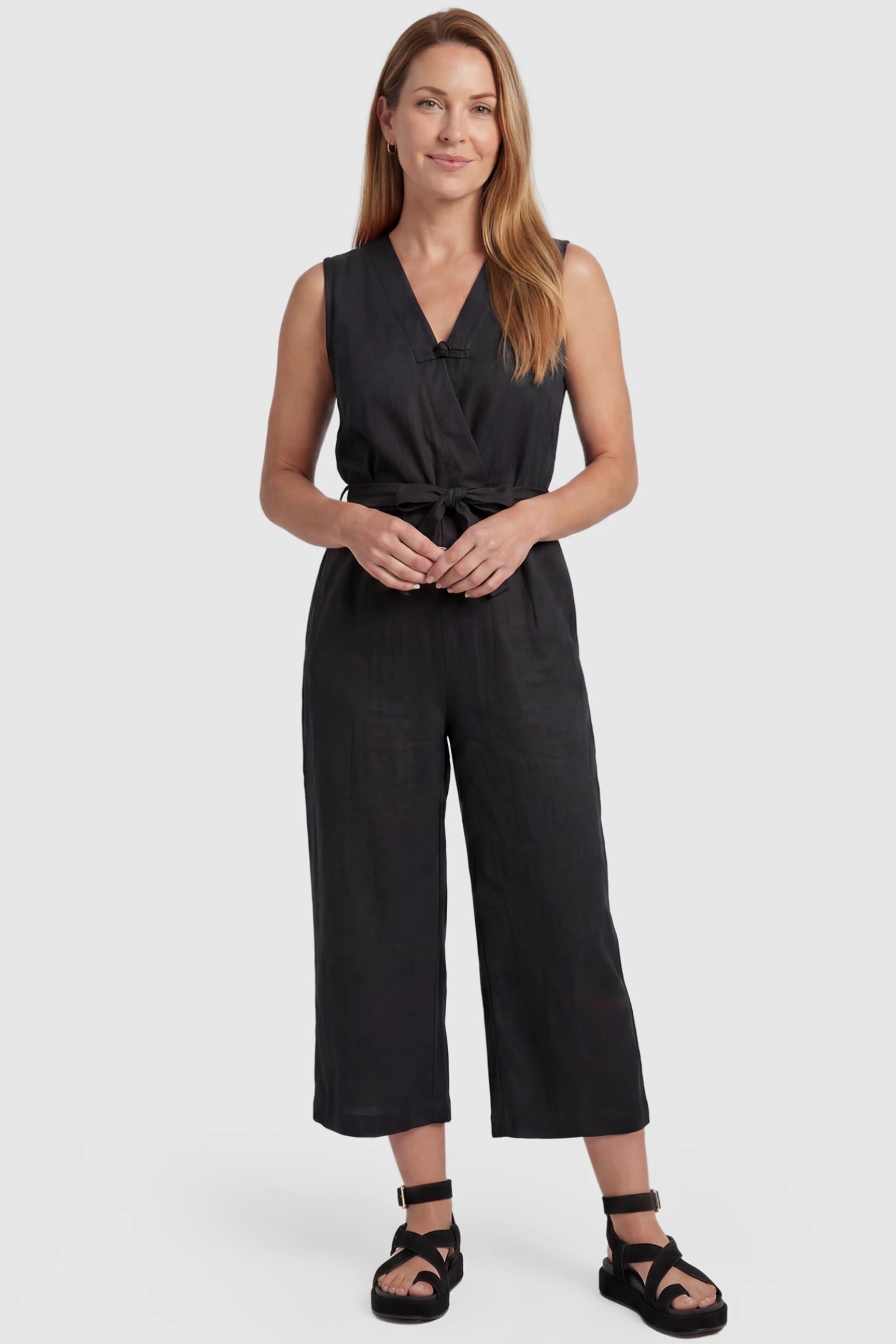 Sleeveless V-Neck Tie-Waist Maternity Jumpsuit Sleeveless V-Neck Tie-Waist Maternity Jumpsuit in Black featuring a relaxed wide-leg design on a postpartum model, front view.