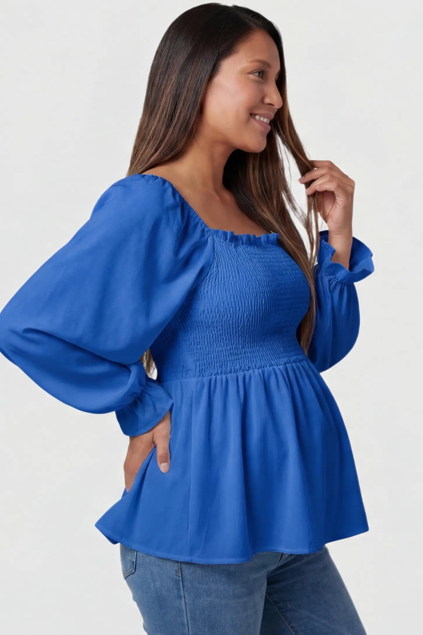 Smocked Convertible Neckline Bishop Sleeve Maternity Top Smocked Convertible Neckline Bishop Sleeve Maternity Top in Blue featuring a peplum hem on a pregnant model side view.