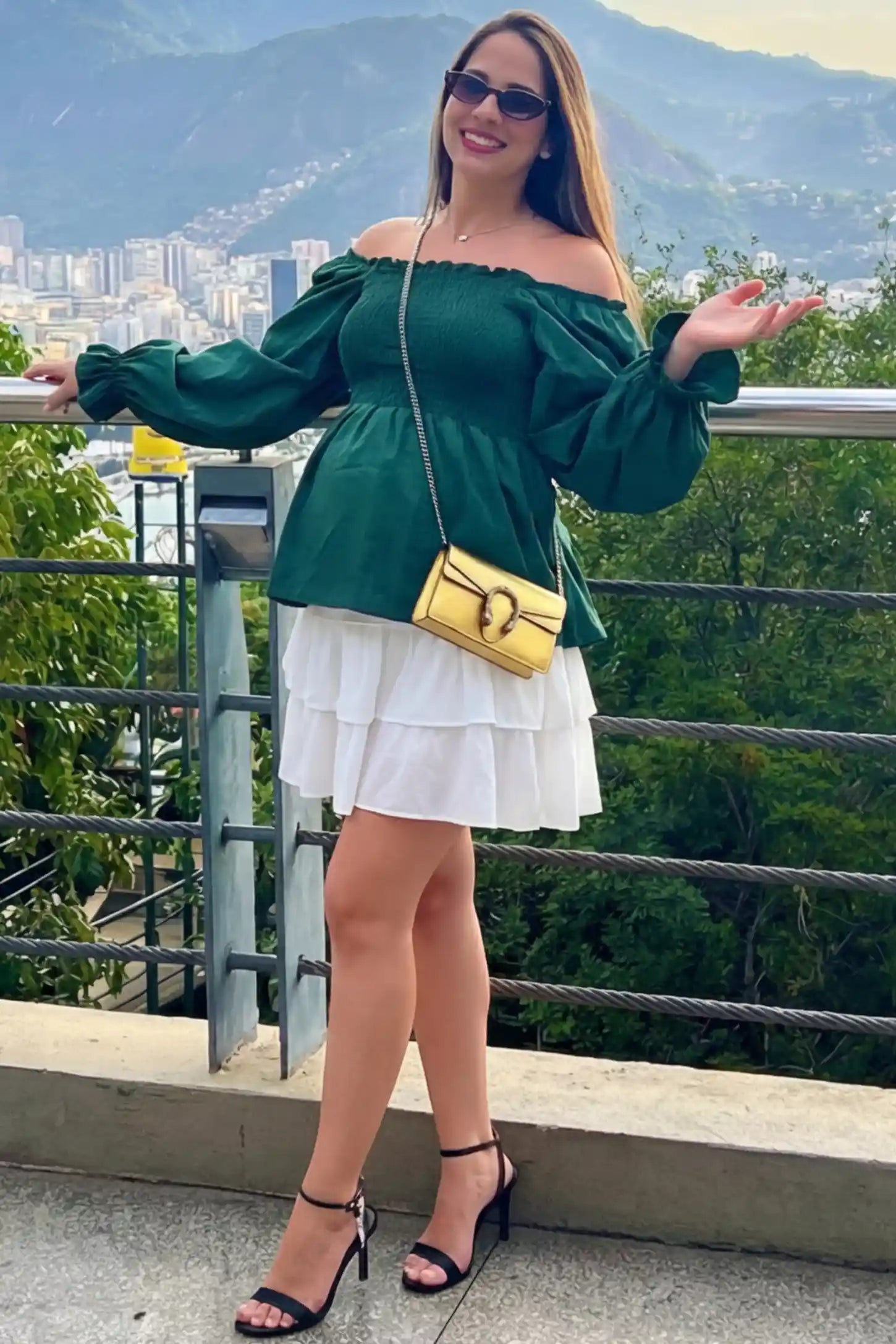 Smocked Convertible Neckline Bishop Sleeve Maternity Top Smocked Convertible Neckline Bishop Sleeve Maternity Top in Green featuring a smocked bodice on a pregnant model in an outdoor setting, front view.