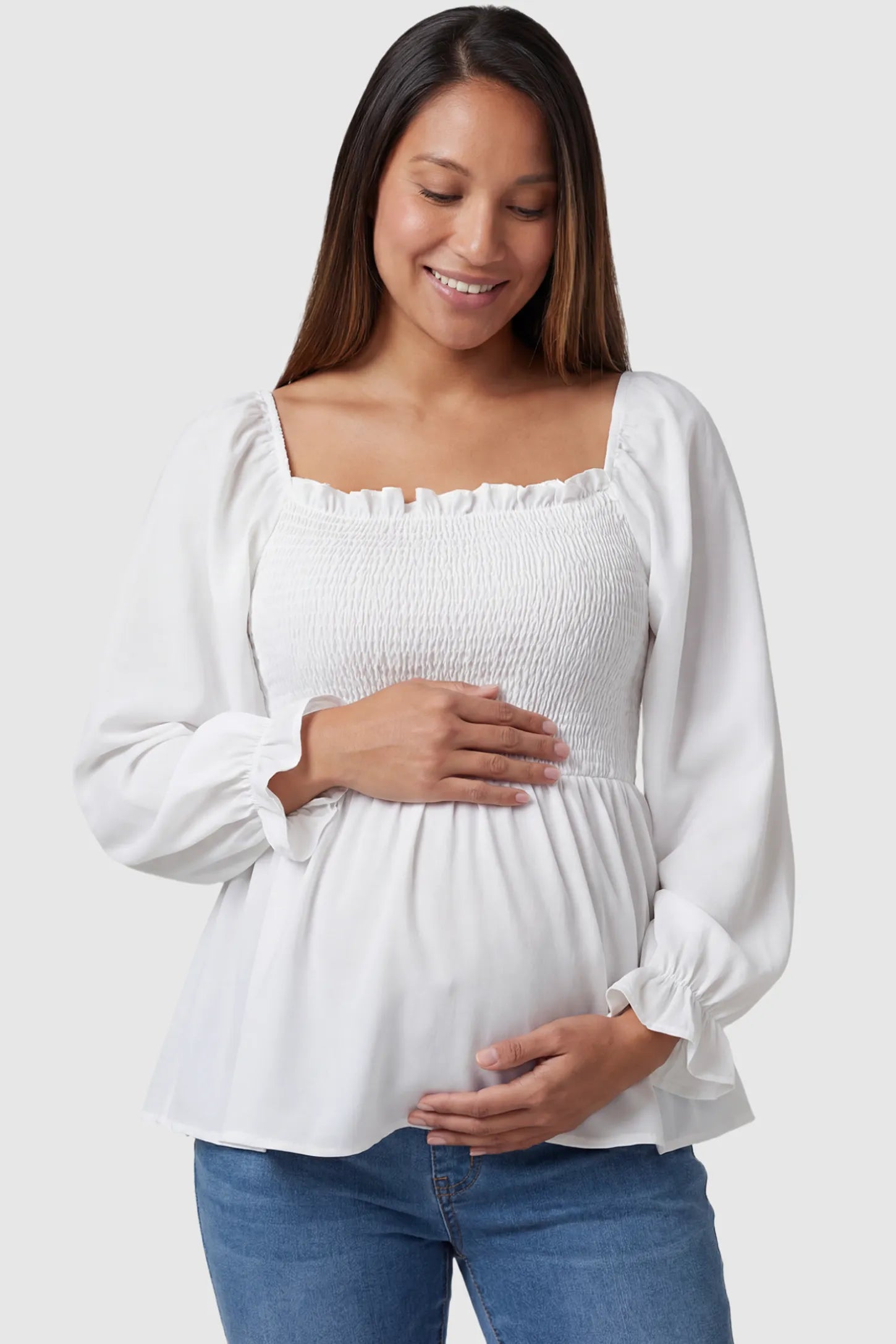 Smocked Convertible Neckline Bishop Sleeve Maternity Top Smocked Convertible Neckline Bishop Sleeve Maternity Top in White featuring a smocked bodice on a pregnant model front view.