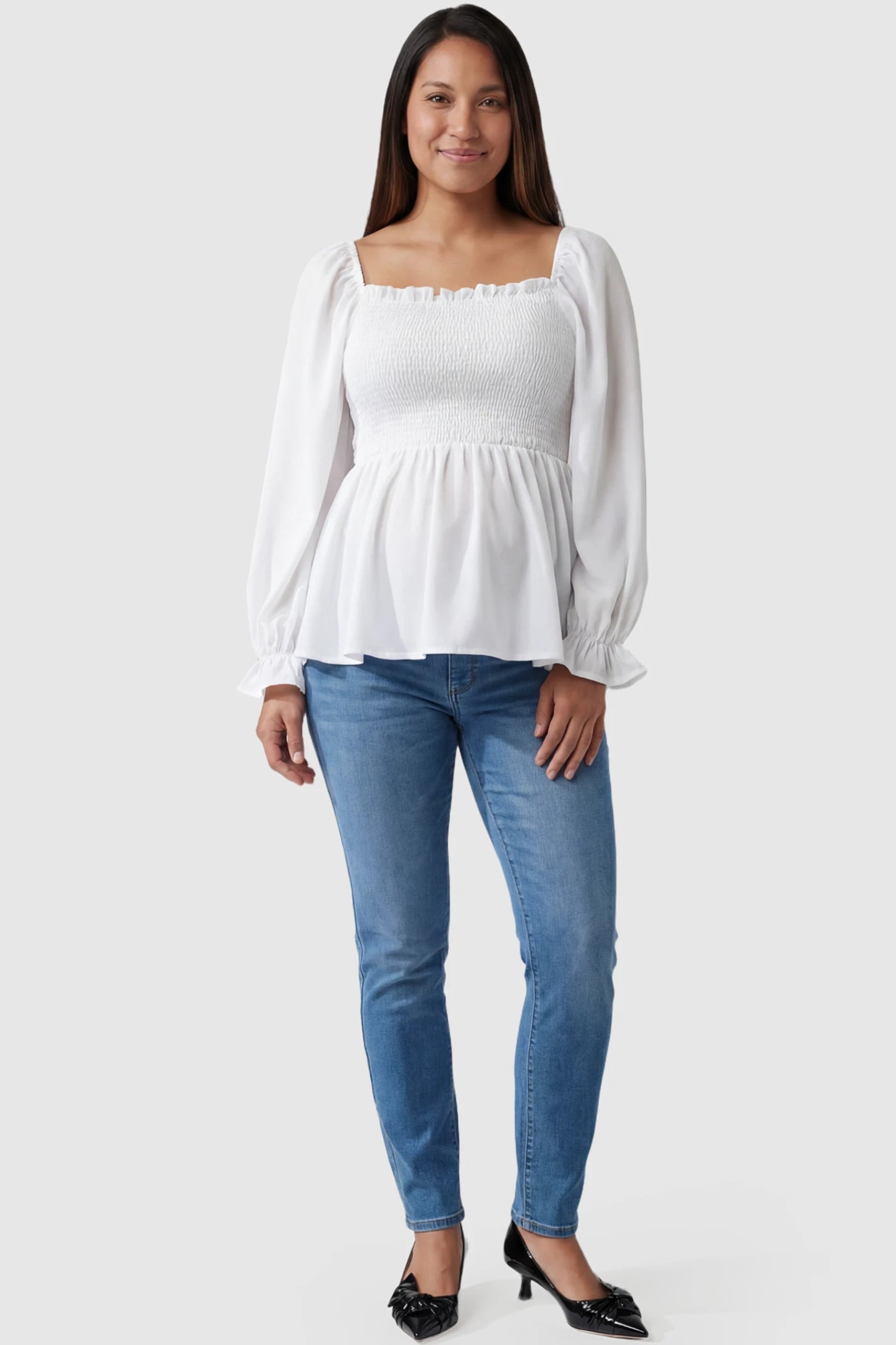 Smocked Convertible Neckline Bishop Sleeve Maternity Top Smocked Convertible Neckline Bishop Sleeve Maternity Top in White featuring a smocked bodice on a pregnant model full body view.
