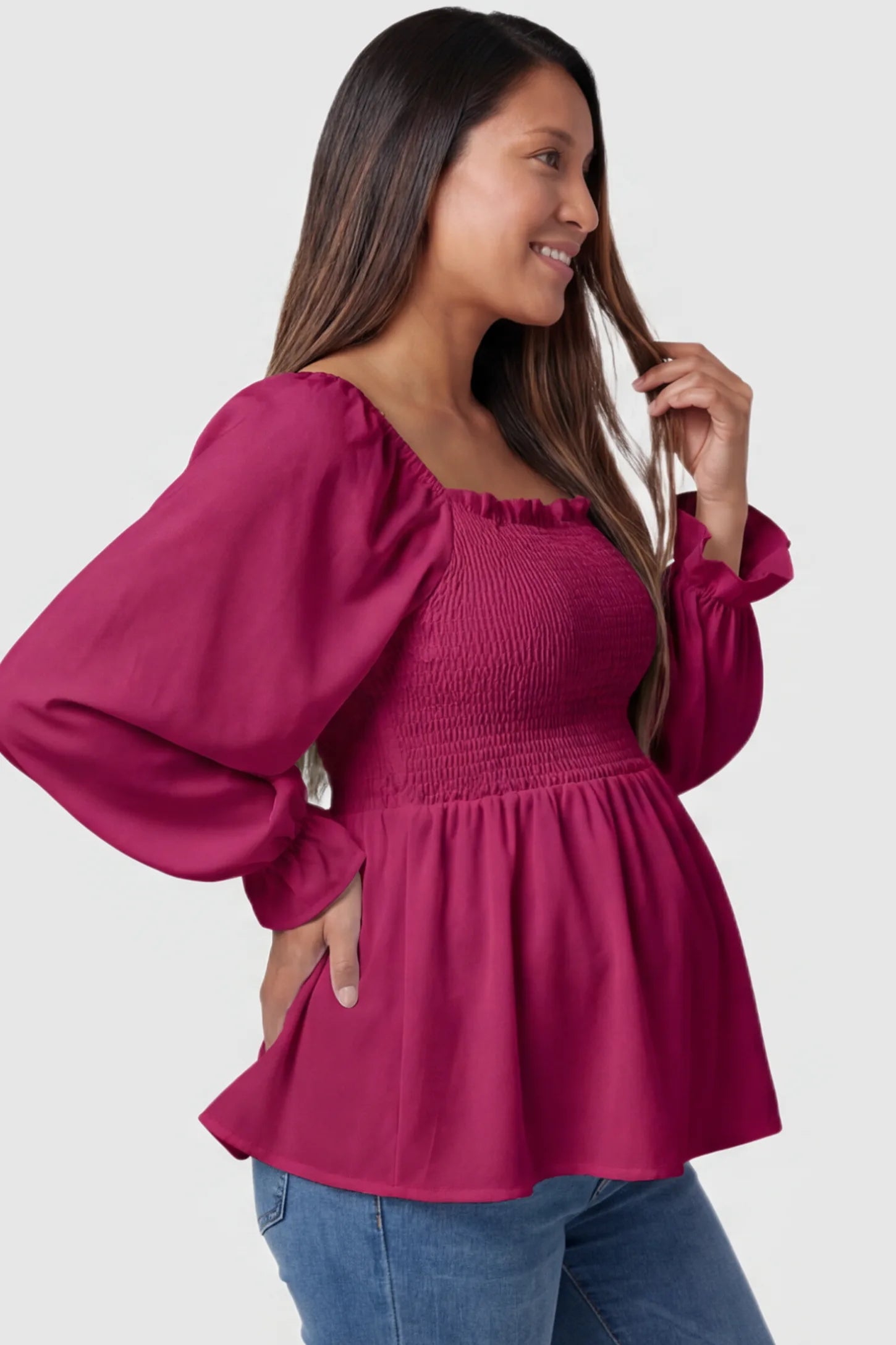 Smocked Convertible Neckline Bishop Sleeve Maternity Top Smocked Convertible Neckline Bishop Sleeve Maternity Top in Wine Red featuring a peplum hem on a pregnant model side view.