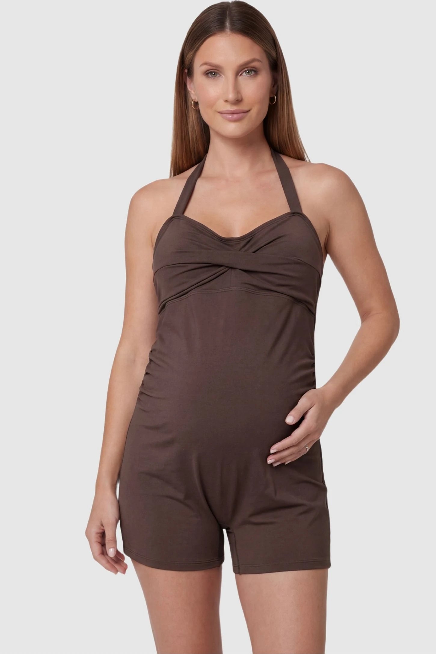 Smooth Halter Stretch Fit Maternity Swim Romper Smooth Halter Stretch Fit Maternity Swim Romper in Brown featuring a twisted sweetheart neckline on a front-facing pregnant model.