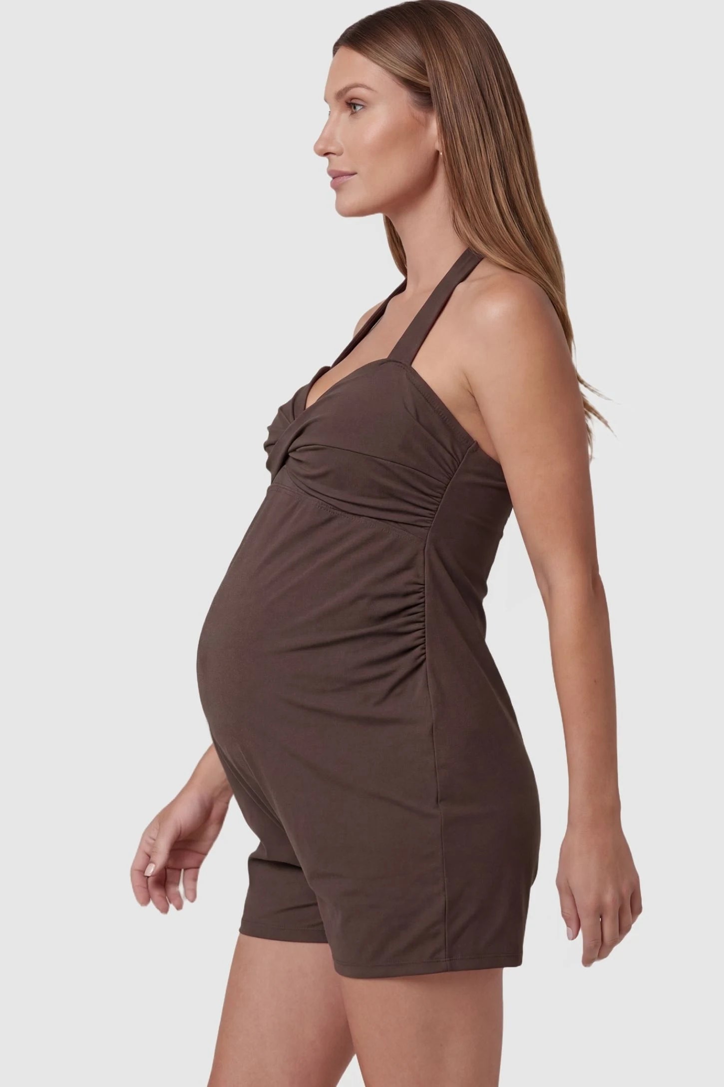 Smooth Halter Stretch Fit Maternity Swim Romper Smooth Halter Stretch Fit Maternity Swim Romper in Brown featuring a side-zip closure for easy wear on a side profile-view pregnant model.