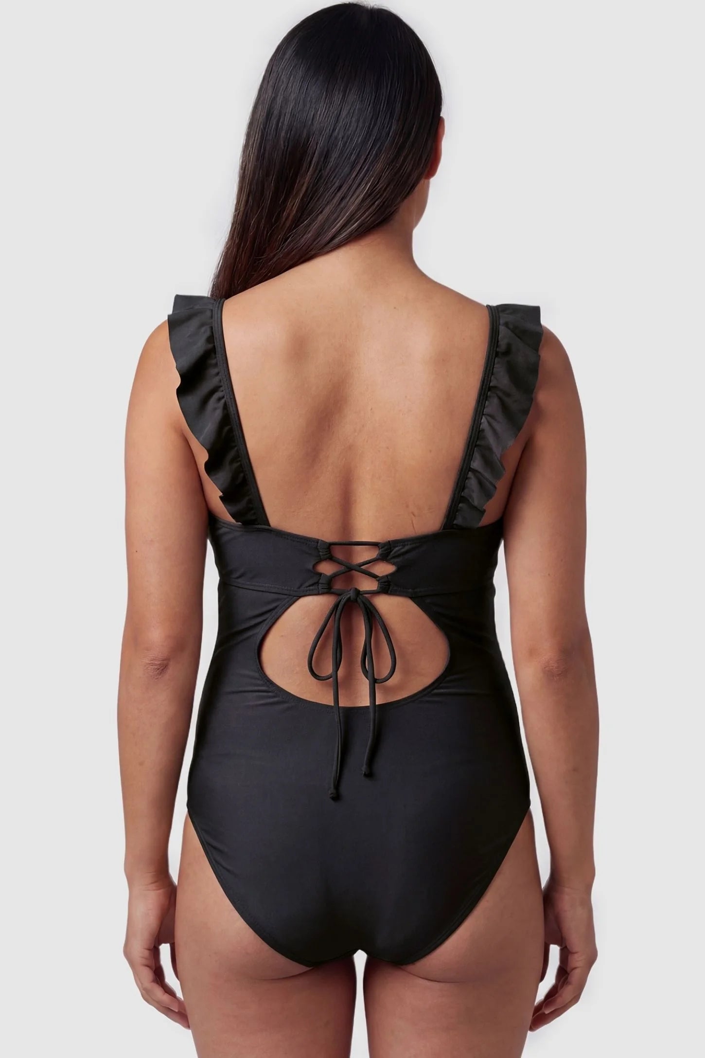 Smooth Matte Ruched Maternity One-Piece Swimsuit Smooth Matte Ruched Maternity One-Piece Swimsuit in Black featuring a lace-up cutout back on a pregnant model, back view.