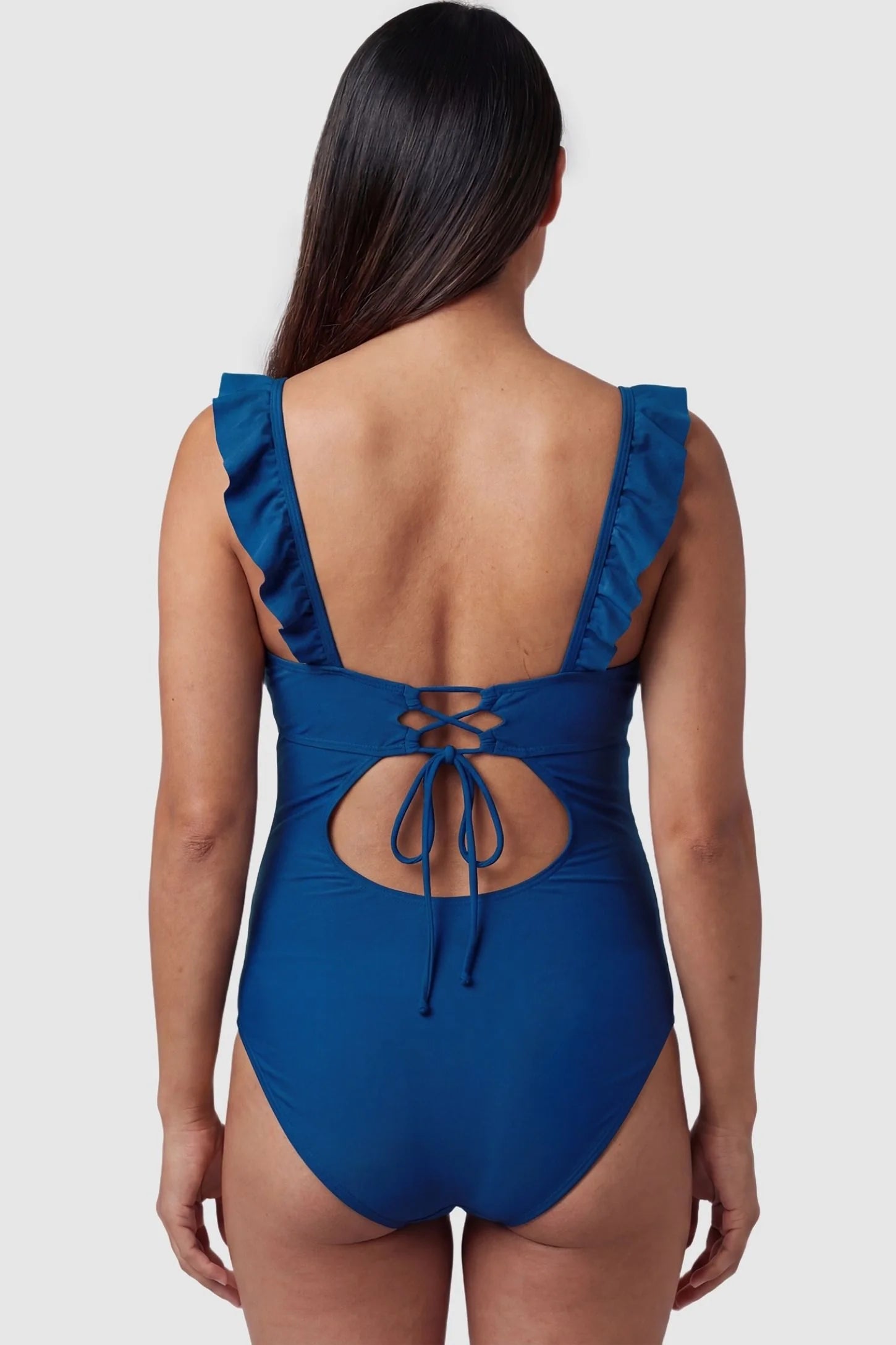 Smooth Matte Ruched Maternity One-Piece Swimsuit Smooth Matte Ruched Maternity One-Piece Swimsuit in Blue featuring a lace-up cutout back on a pregnant model, back view.
