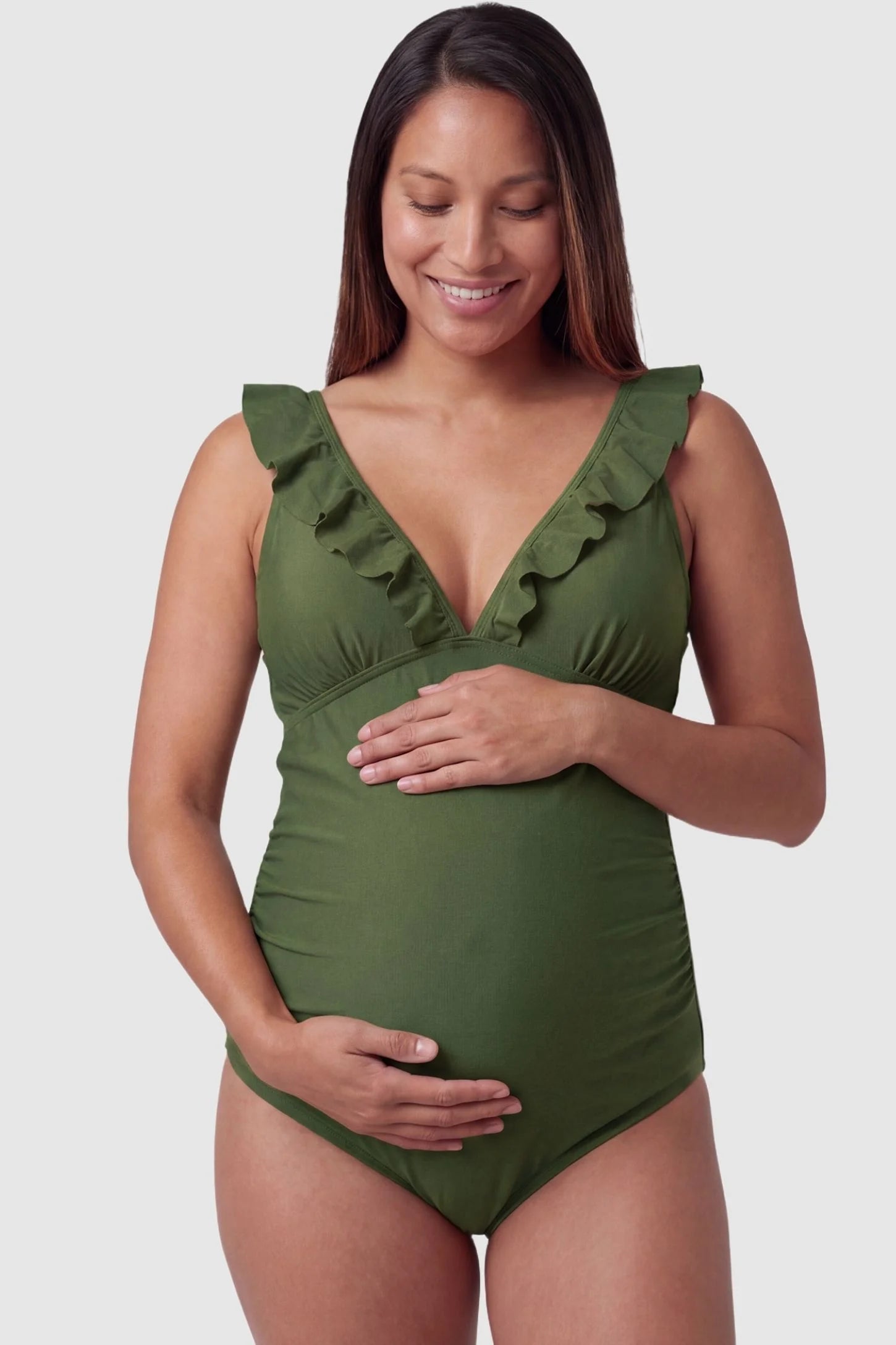 Smooth Matte Ruched Maternity One-Piece Swimsuit Smooth Matte Ruched Maternity One-Piece Swimsuit in Green featuring ruffle straps and a V-neck front on a pregnant model, front view.
