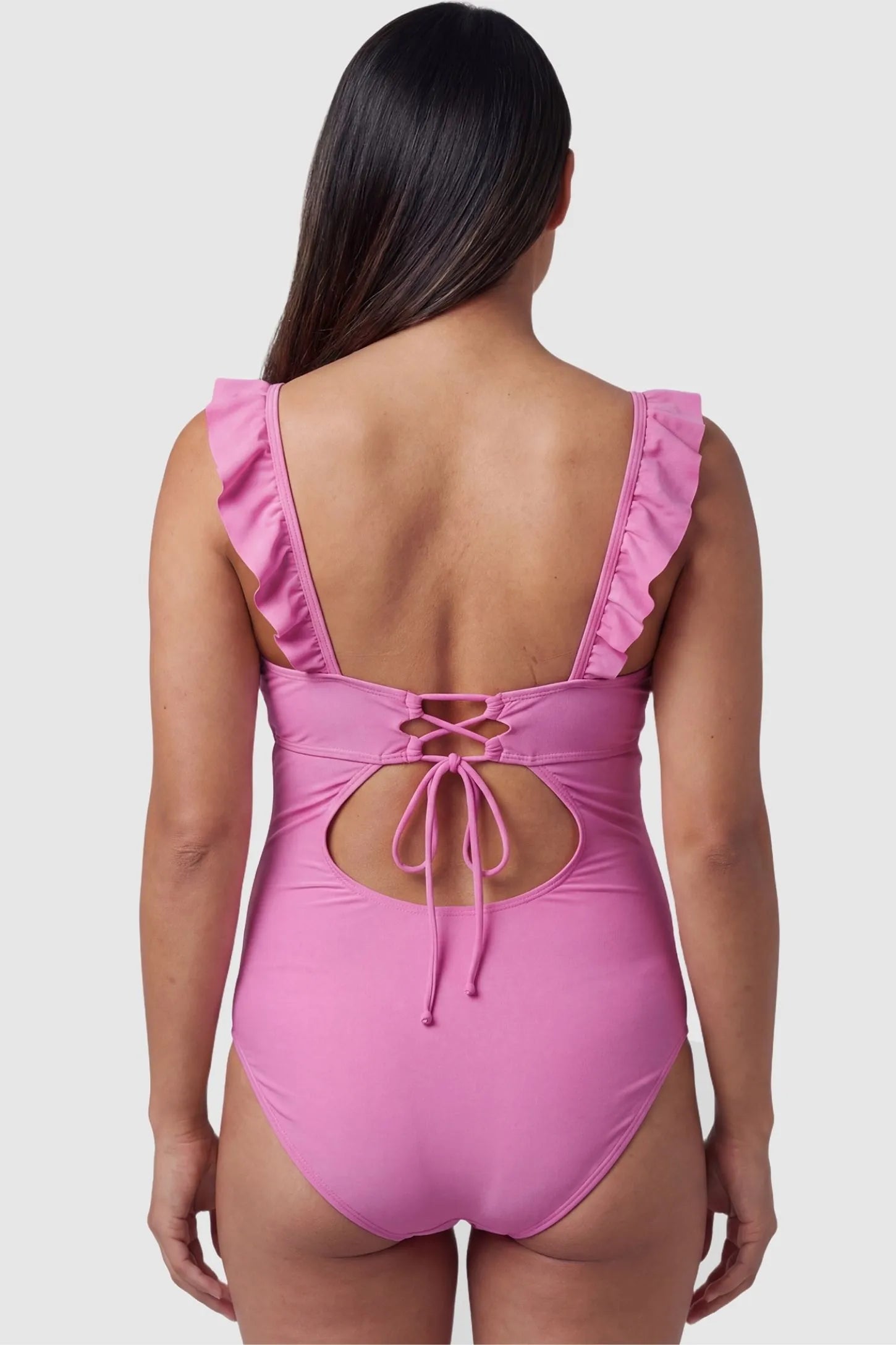 Smooth Matte Ruched Maternity One-Piece Swimsuit Smooth Matte Ruched Maternity One-Piece Swimsuit in Pink featuring a lace-up cutout back on a pregnant model, back view.