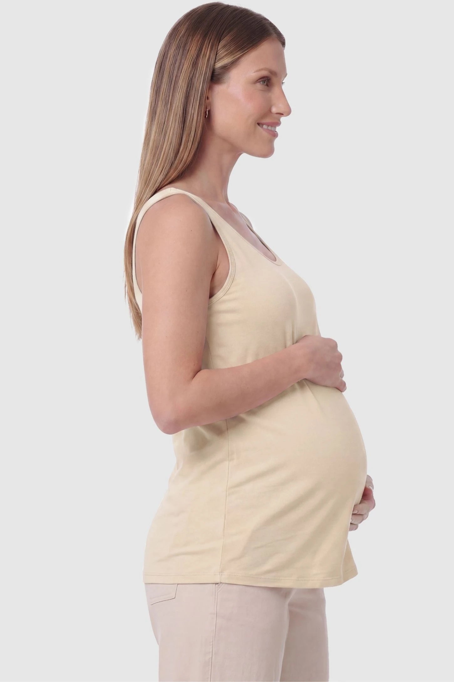 Soft Knit Sleeveless Maternity Tank Top  Soft Knit Sleeveless Maternity Tank Top in Beige featuring a straight hemline on a pregnant model, side view.