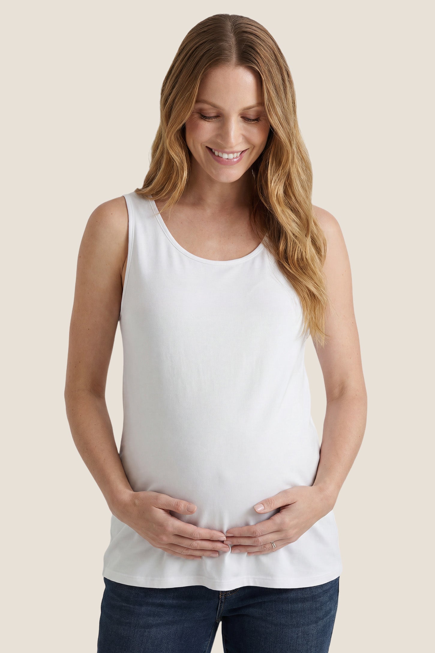Soft Knit Sleeveless Maternity Tank Top in White featuring a scoop neckline on a pregnant model, front view.
