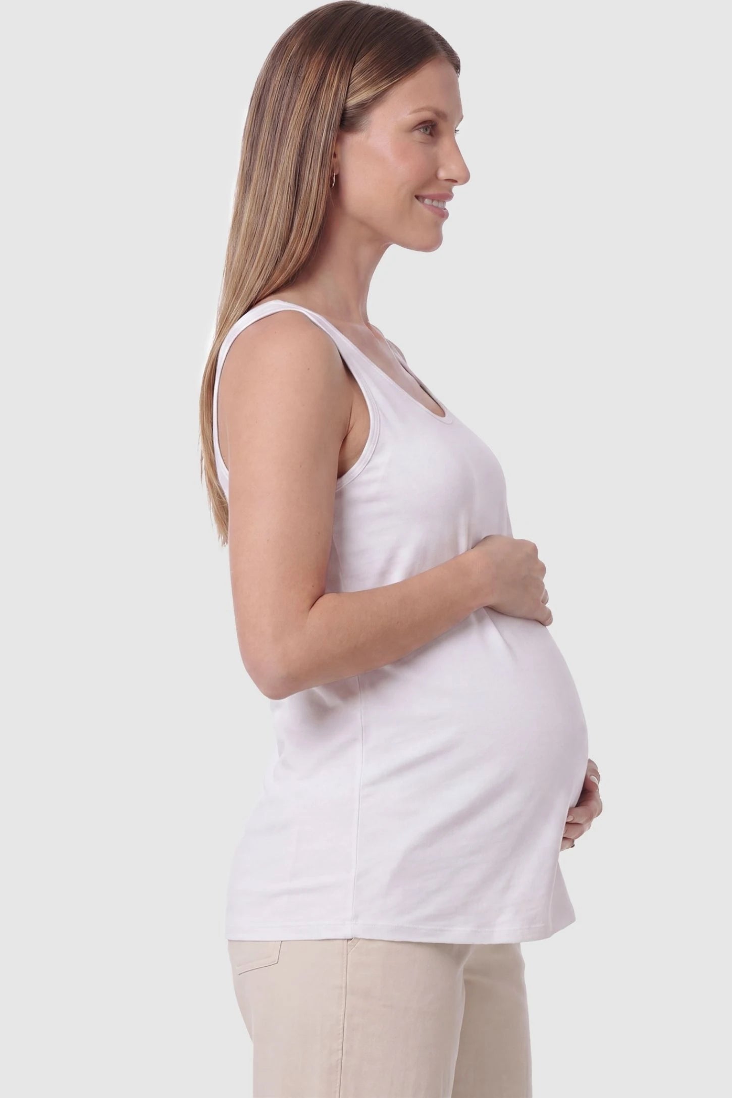 Soft Knit Sleeveless Maternity Tank Top in White featuring a straight hemline on a pregnant model, side view.