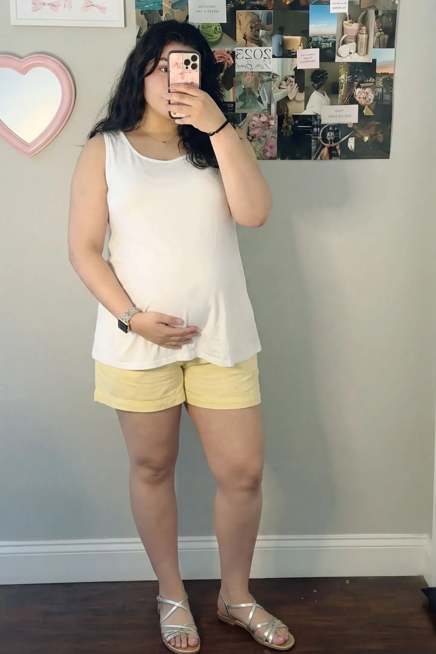 Soft Knit Sleeveless Maternity Tank Top Soft Knit Sleeveless Maternity Tank Top in White featuring stretchy breathable fabric on a pregnant woman in a mirror selfie.
