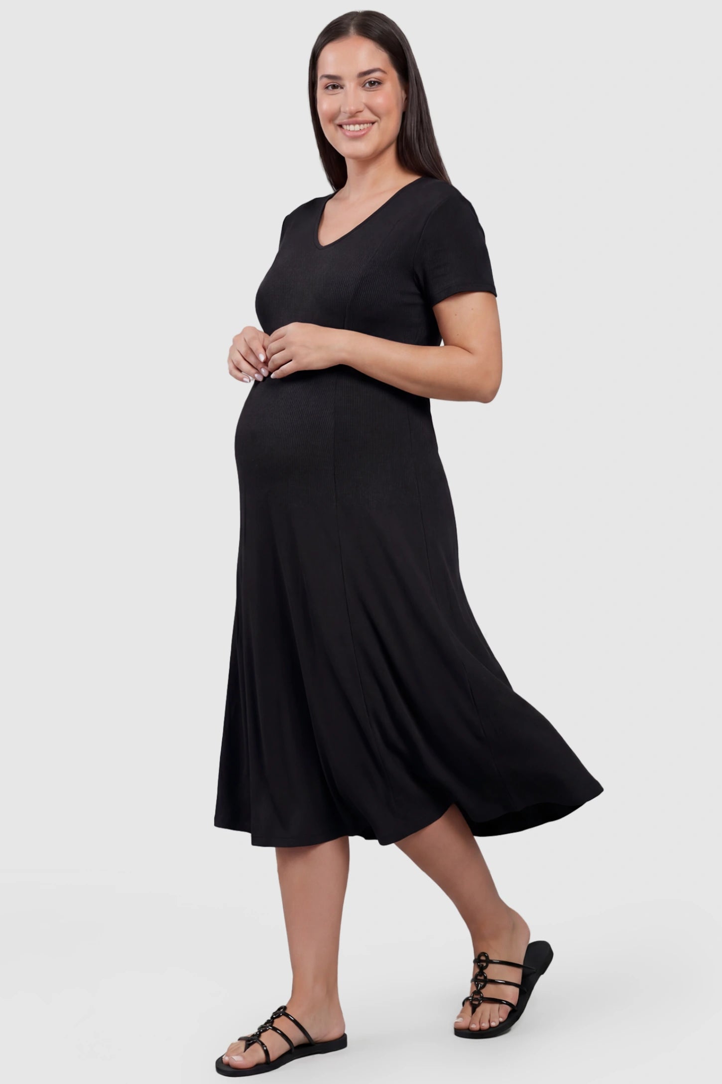 Soft Knit Stretch Short Sleeve Maternity Midi Dress Soft Knit Stretch Short Sleeve Maternity Midi Dress in Black featuring a flattering v-neck and high stretch knit on a plus size pregnant model, front view.