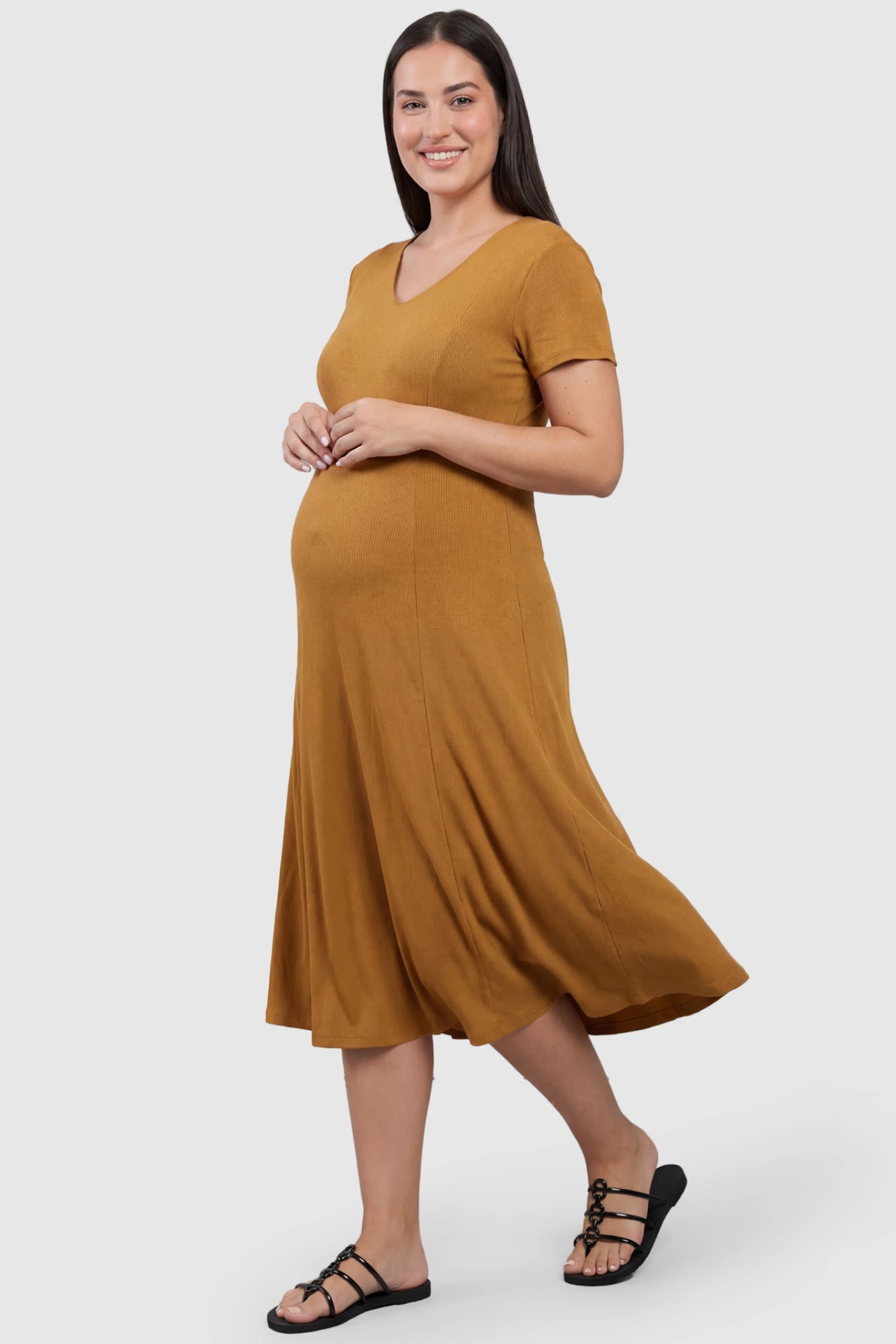 Soft Knit Stretch Short Sleeve Maternity Midi Dress Soft Knit Stretch Short Sleeve Maternity Midi Dress in Camel featuring a flattering v-neck and high stretch knit on a plus size pregnant model, front view.
