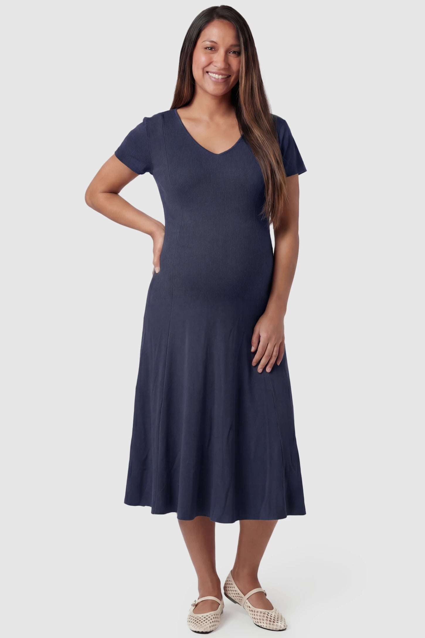 Soft Knit Stretch Short Sleeve Maternity Midi Dress Soft Knit Stretch Short Sleeve Maternity Midi Dress in Dark Gray featuring a flattering v-neck and high stretch knit on a pregnant model, front view.