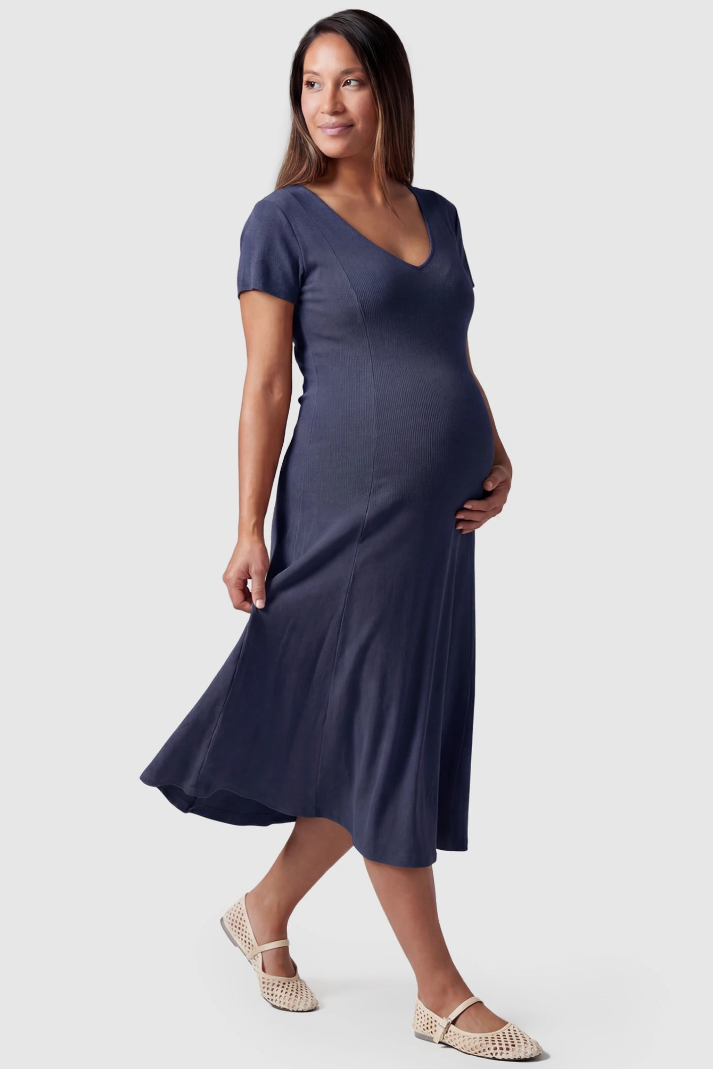 Soft Knit Stretch Short Sleeve Maternity Midi Dress Soft Knit Stretch Short Sleeve Maternity Midi Dress in Dark Gray featuring a flattering v-neck and high stretch knit on a pregnant model, side view.