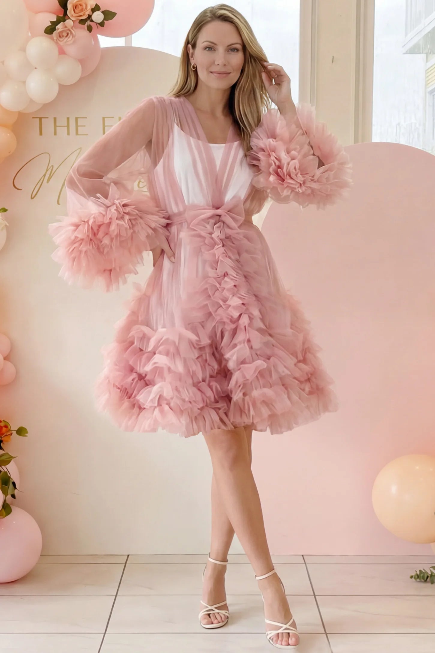 Soft Nylon Mesh Long Sleeve Maternity Photoshoot Dress Soft Nylon Mesh Long Sleeve Maternity Photoshoot Dress in Pink featuring sheer V-neck, ruffle trim layered hem on a postpartum model at a baby shower, front view.